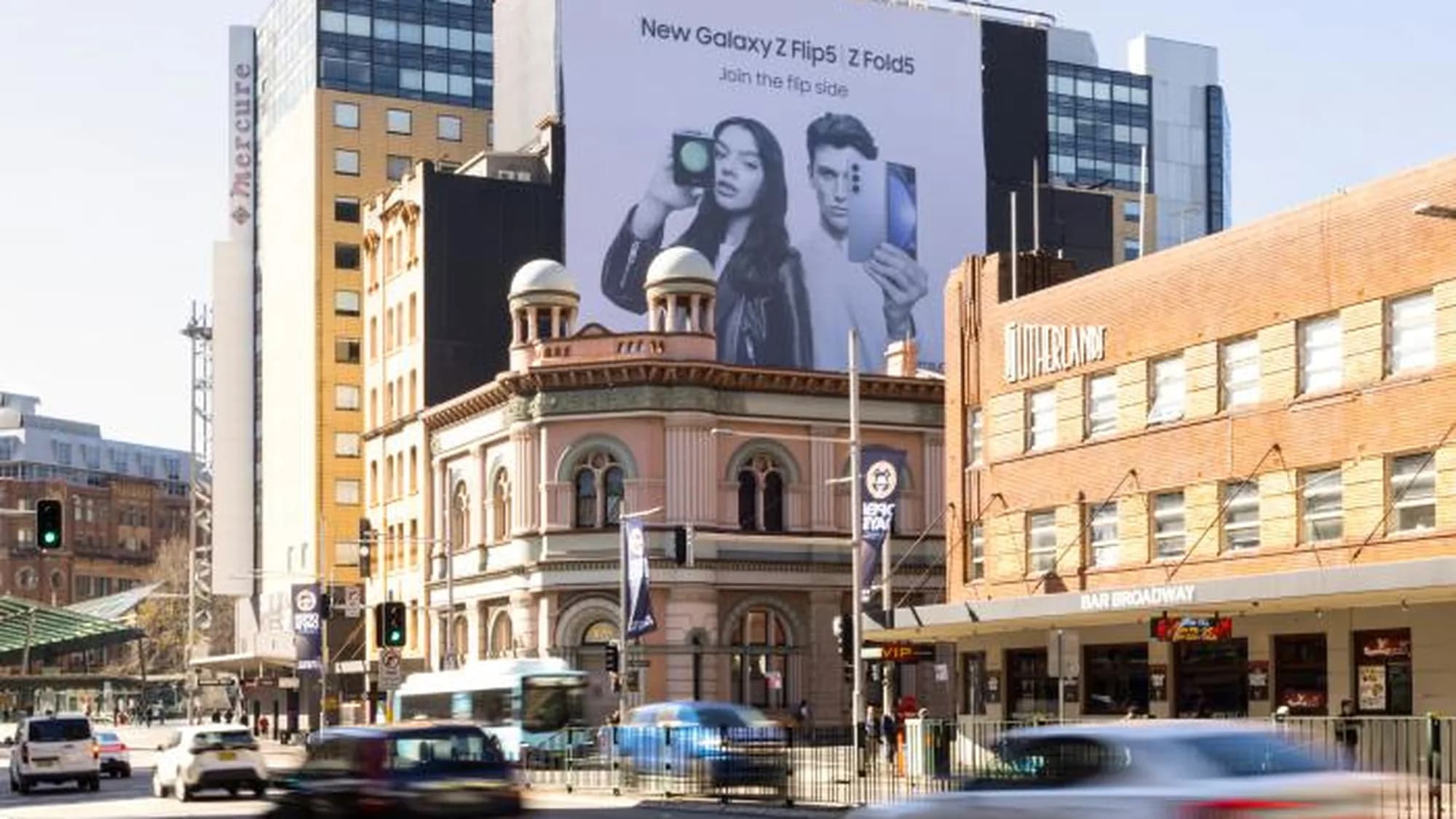 Billboard advertising on George Street in Sydney, Australia: a Samsung Galaxy Z Flip5 and Z Fold5 board towers over a heritage corner.
