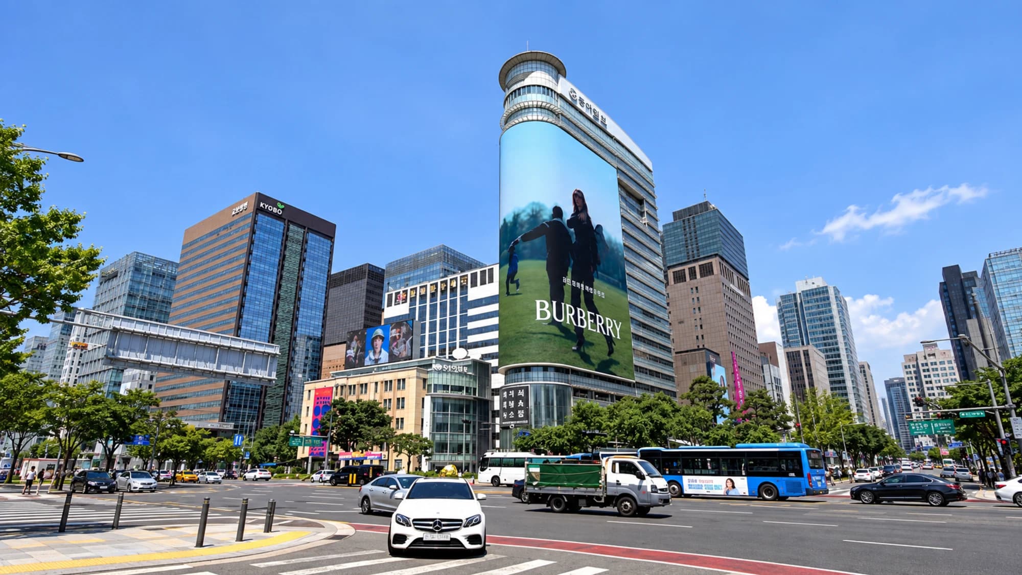 Digital billboard advertising at Gwanghwamun in Seoul, South Korea: a curved screen wraps a tower facing the busy junction near the Kyobo building.