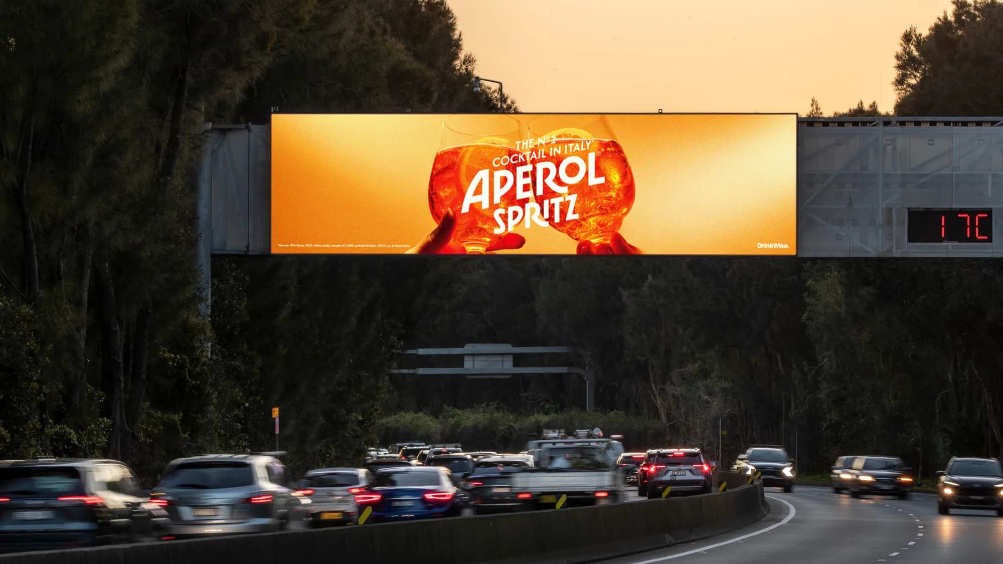 Billboard advertising in Sydney, Australia: an Aperol Spritz board spans a highway gantry above evening traffic.