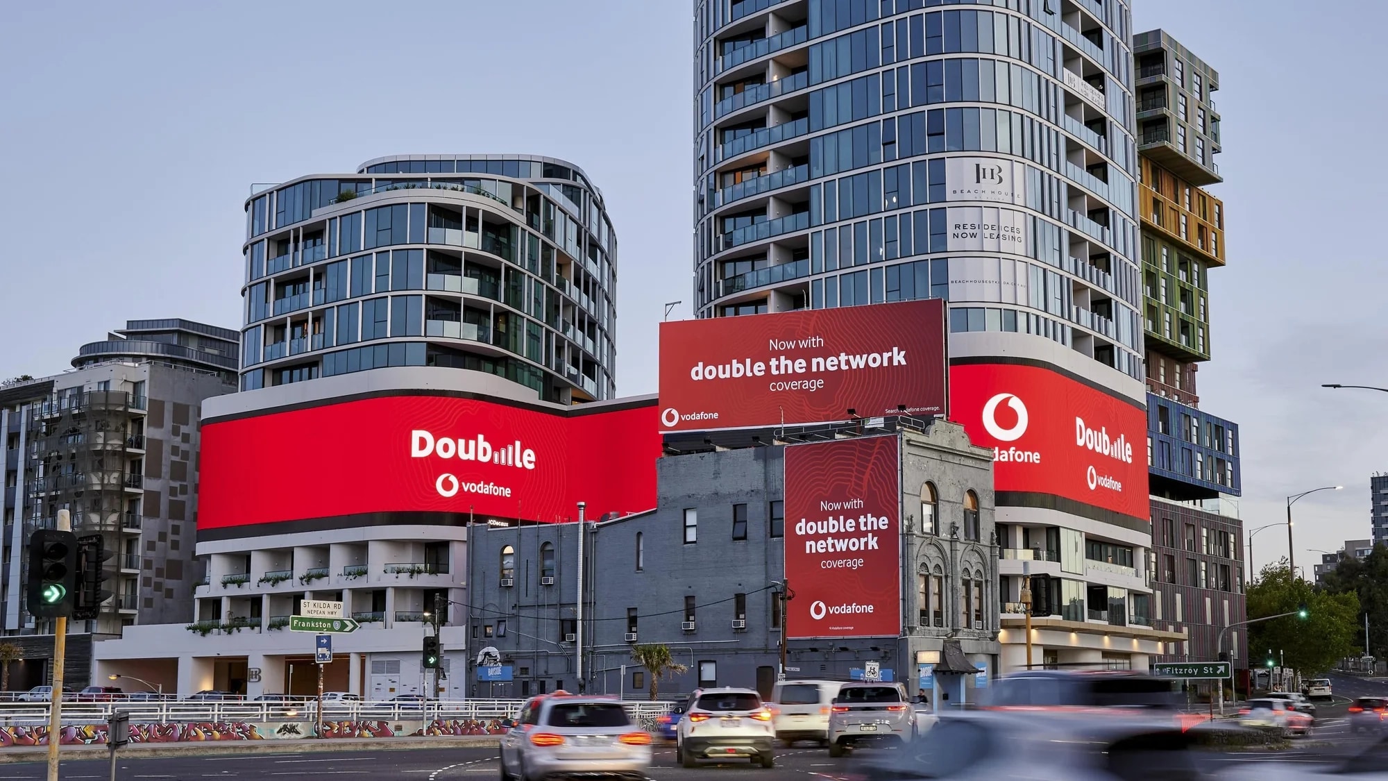 Billboard advertising in Australia: large red Vodafone boards on a city street read Double, now with double the network coverage.