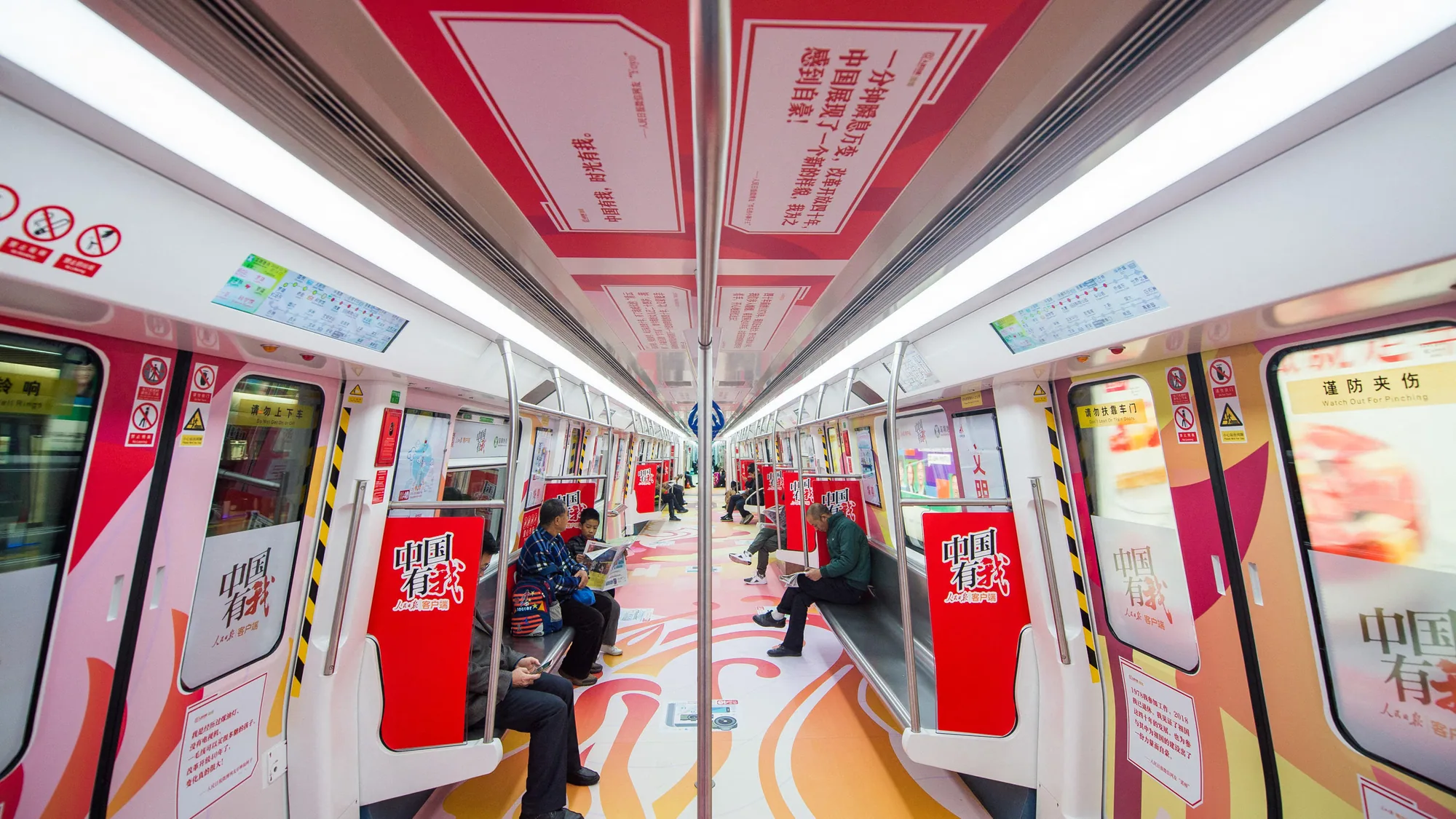 Metro advertising in China: a carriage is wrapped in the 中国有我 theme, with red seat panels and colourful floor graphics.