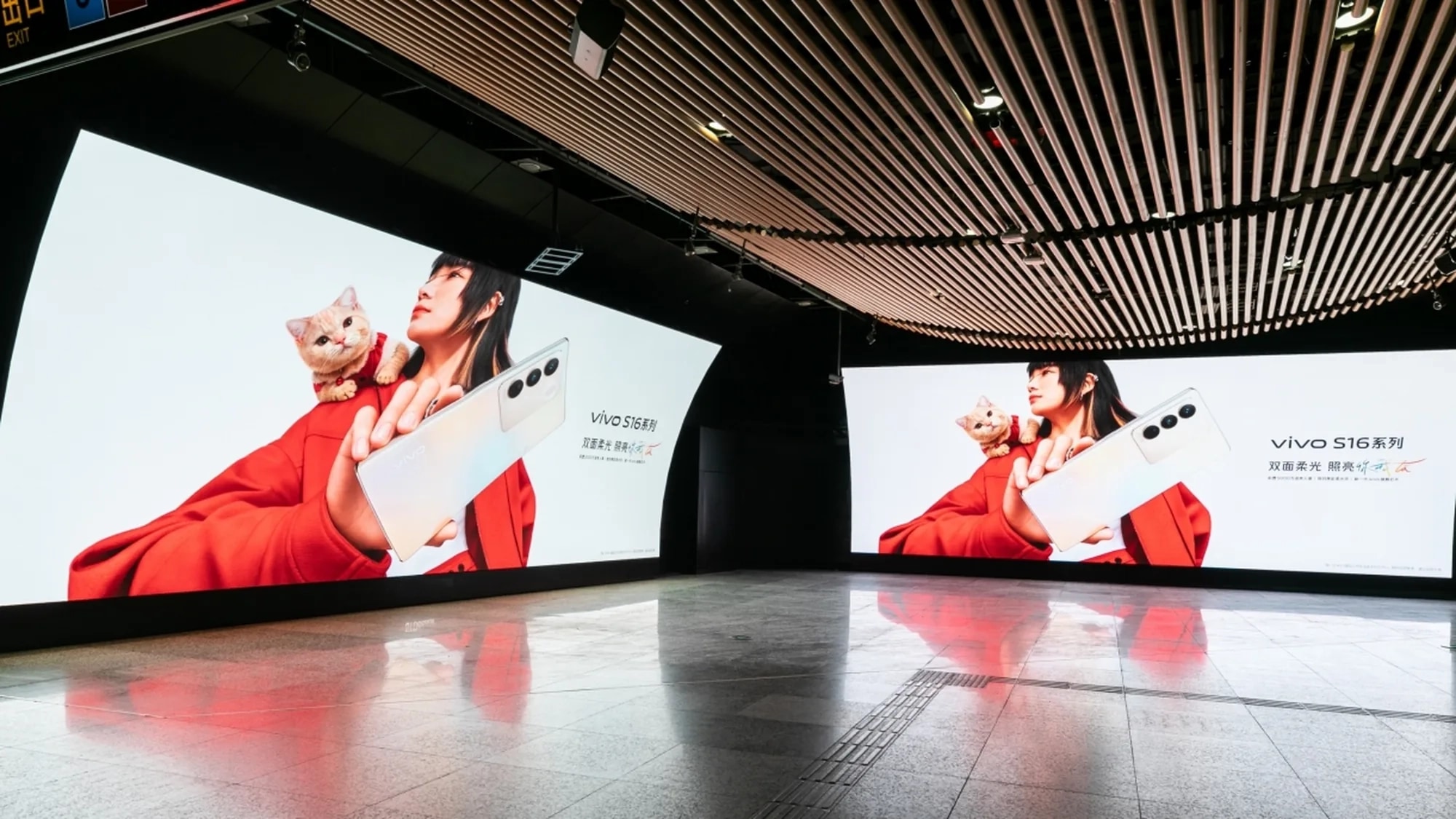 Programmatic digital advertising in China: two large screens advertise the vivo S16 series, showing a woman in red with a phone and a cat.