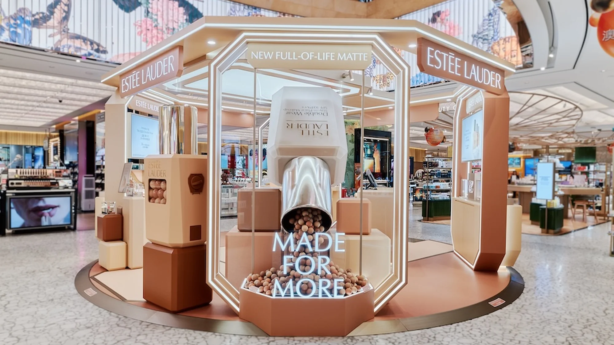 An Estée Lauder brand activation shows a giant foundation bottle spilling pearls, with the lines New Full-of-Life Matte and Made for More.