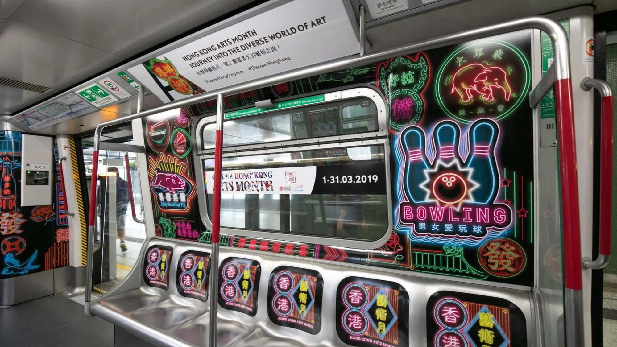 Transit advertising in Hong Kong: the inside of a train is wrapped for Hong Kong Arts Month, with neon illustrations and the dates 1 to 31 March 2019.