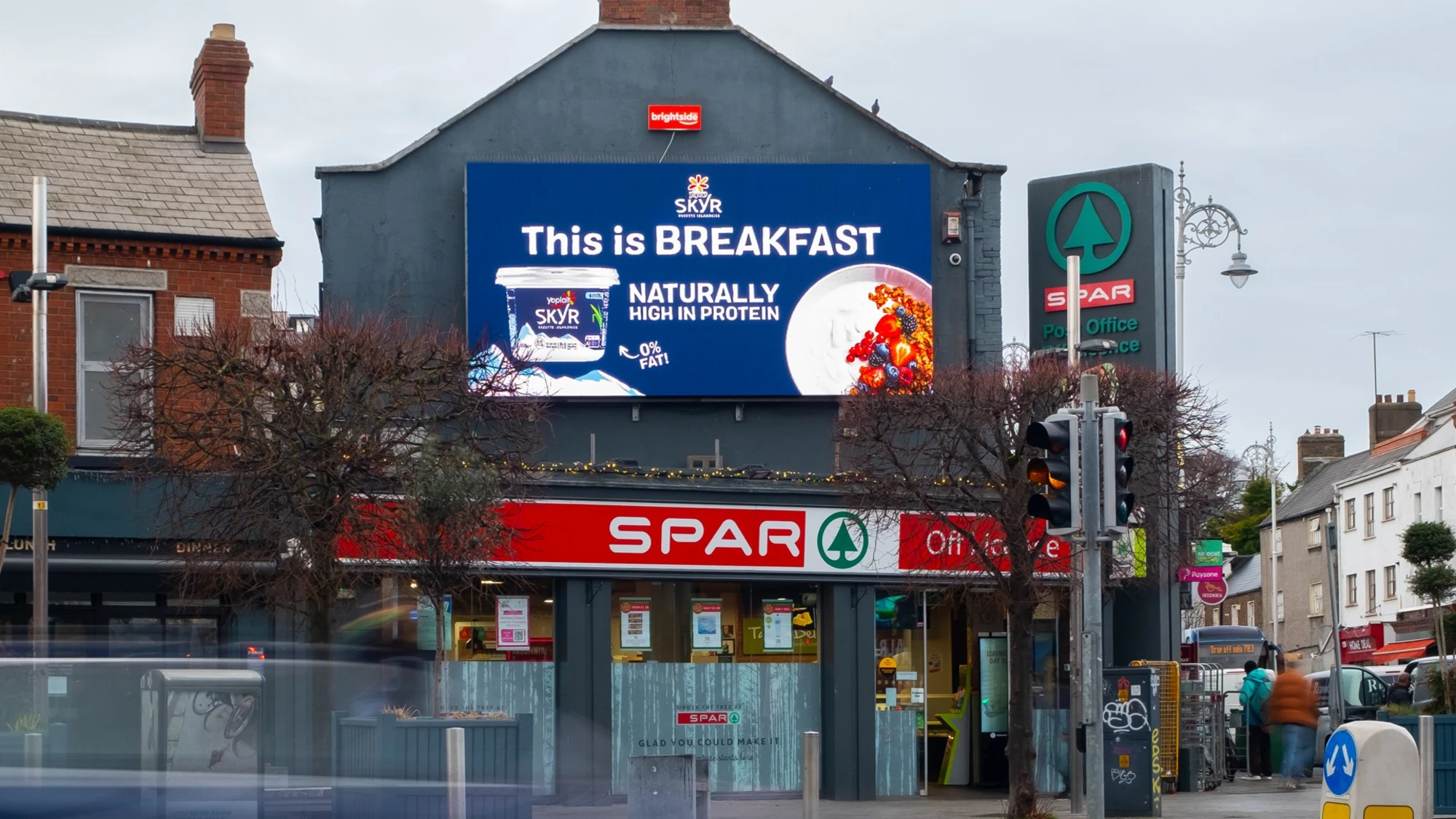 Digital billboard advertising in Ireland: a screen above a SPAR shop advertises Skyr with the lines This is breakfast and Naturally high in protein.