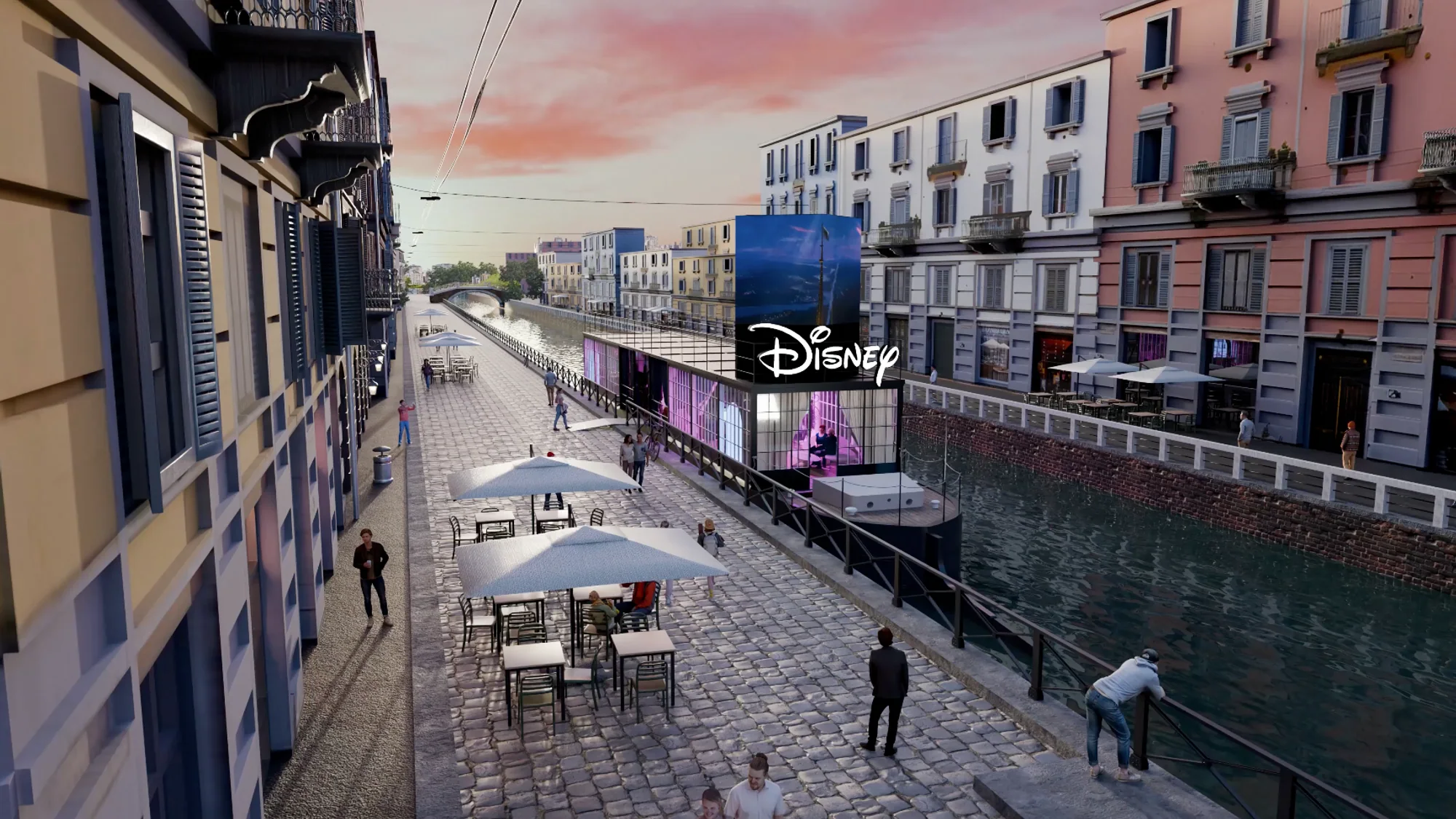 A Disney brand activation in Italy: a glass pavilion with a large screen sits beside a canal and outdoor cafe tables.