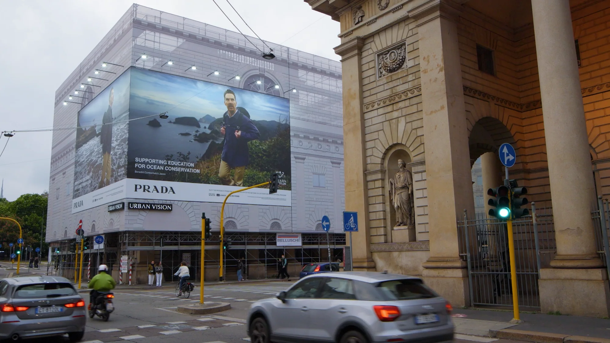 Building banner advertising in Italy: a Prada banner reading Supporting education for ocean conservation covers a scaffolded building on a city street.