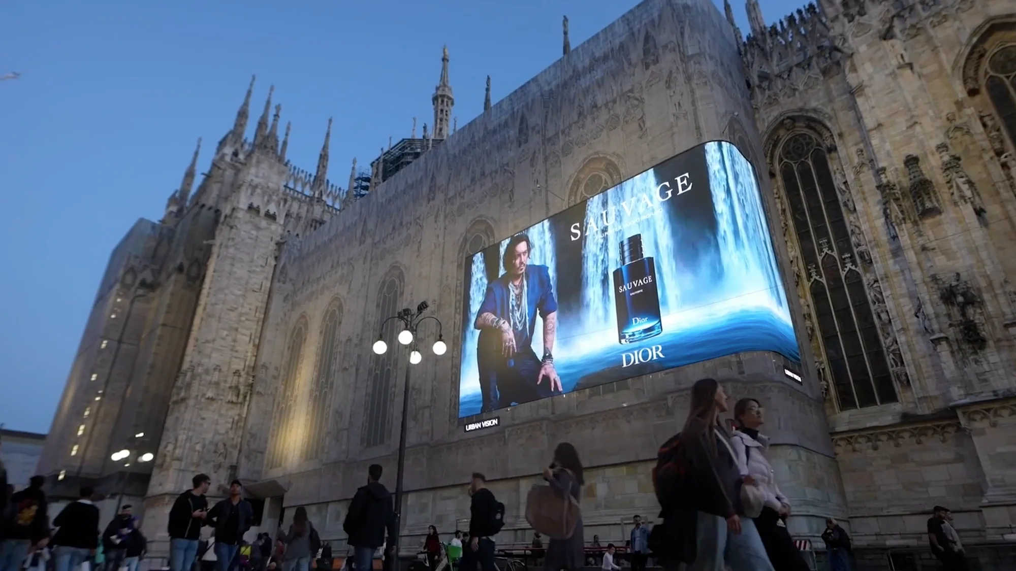 Digital out-of-home advertising in Milan, Italy: a Dior Sauvage screen showing Johnny Depp and the fragrance bottle is mounted on the Duomo.