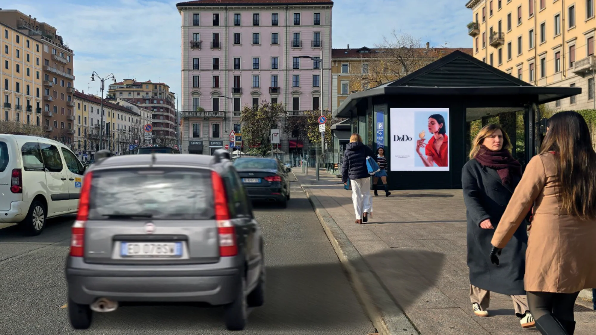 Street furniture advertising in Italy: a DoDo jewellery advert of a woman with a charm is displayed in a bus shelter.