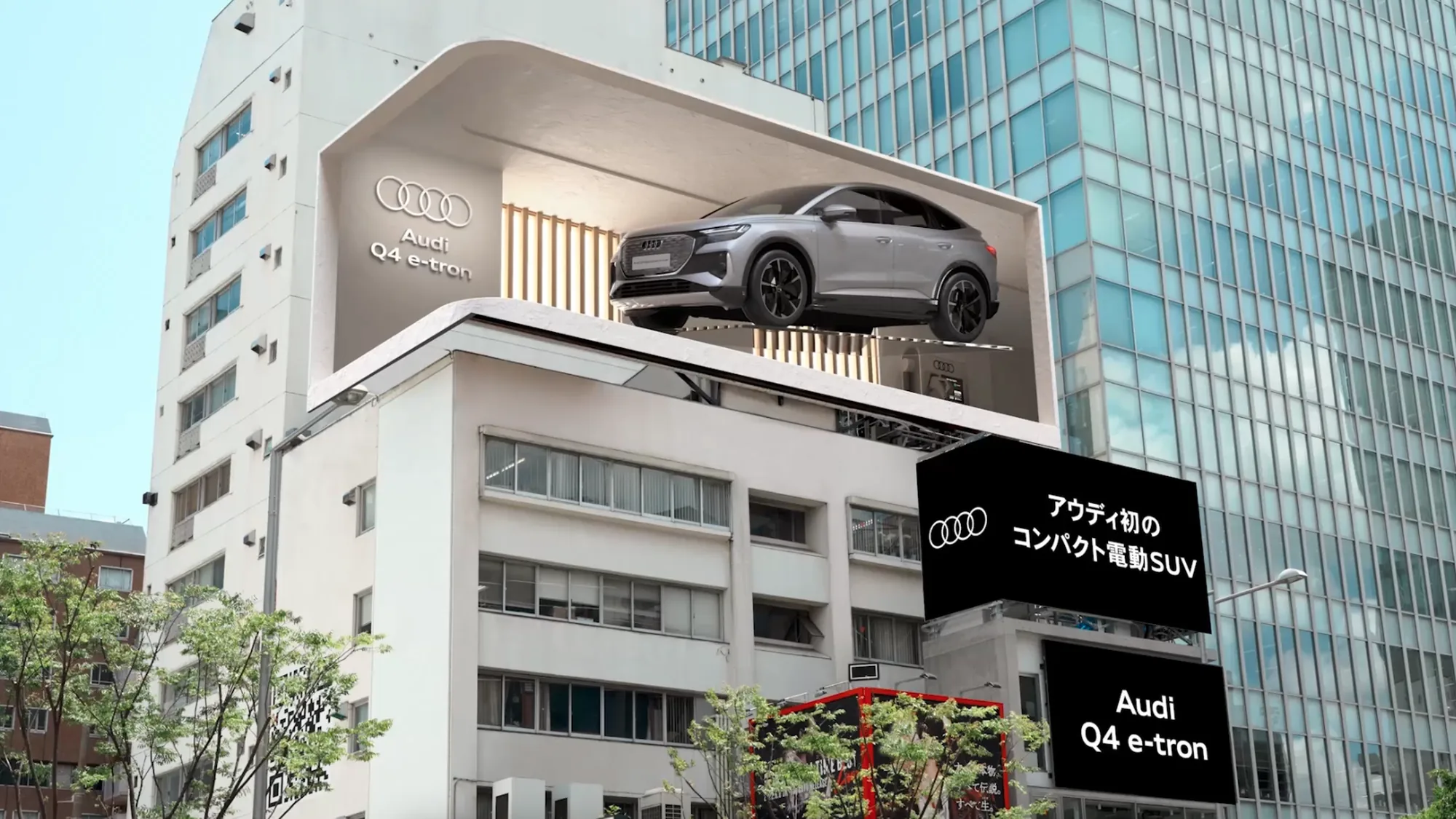 Digital out-of-home advertising in Japan: a 3D billboard shows a silver Audi Q4 e-tron set into the face of a building, with signs for the compact electric SUV.