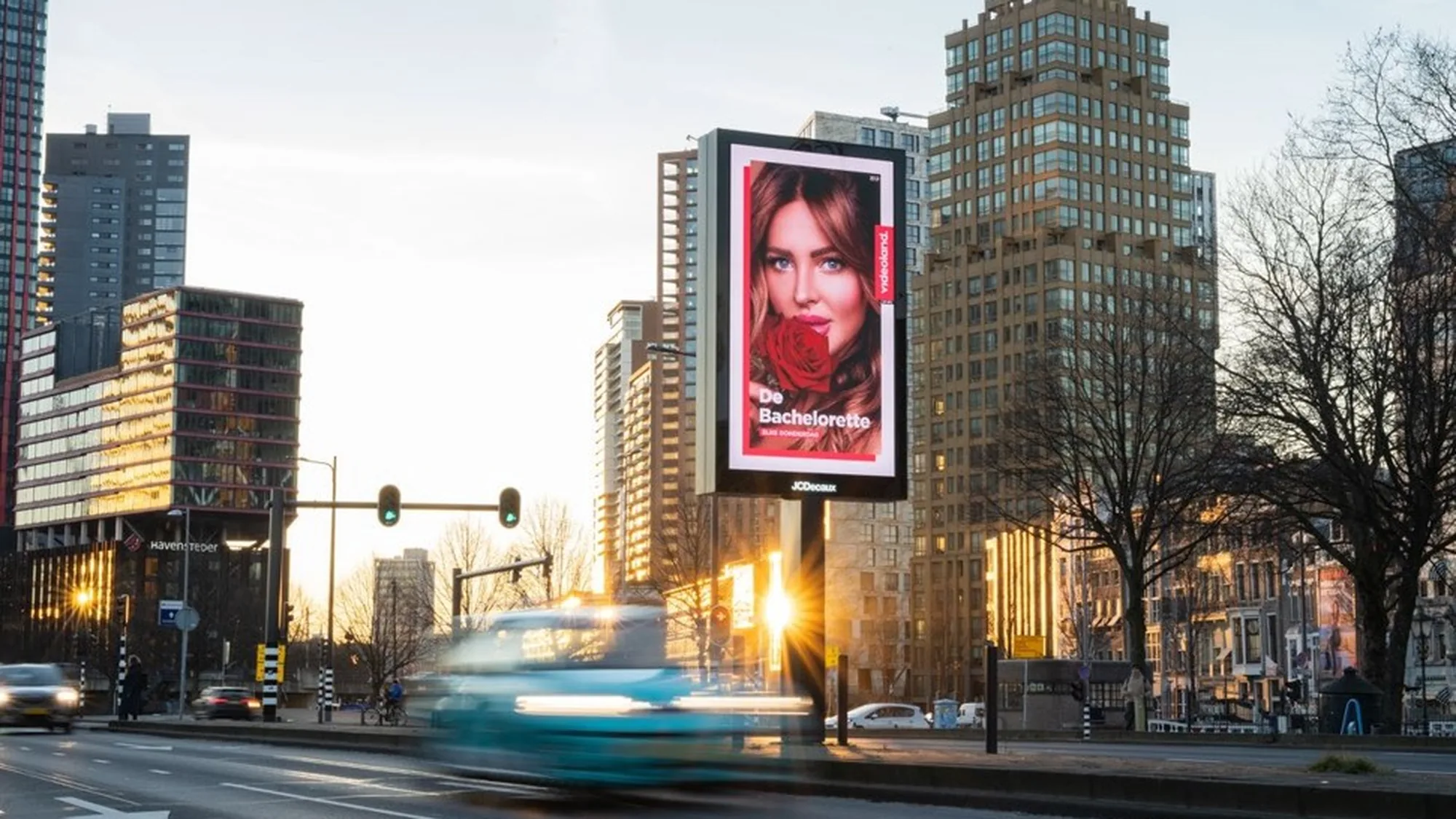 Digital out-of-home advertising in the Netherlands: a roadside billboard in a Dutch city advertises The Bachelorette on Videoland, with a woman holding a red rose.