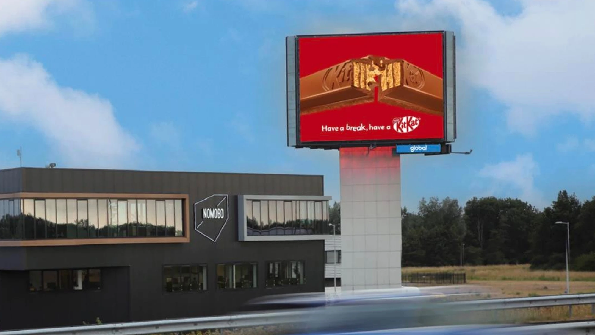 Billboard advertising in the Netherlands: a roadside screen shows a KitKat bar on a red background, with the line Have a break, have a KitKat.