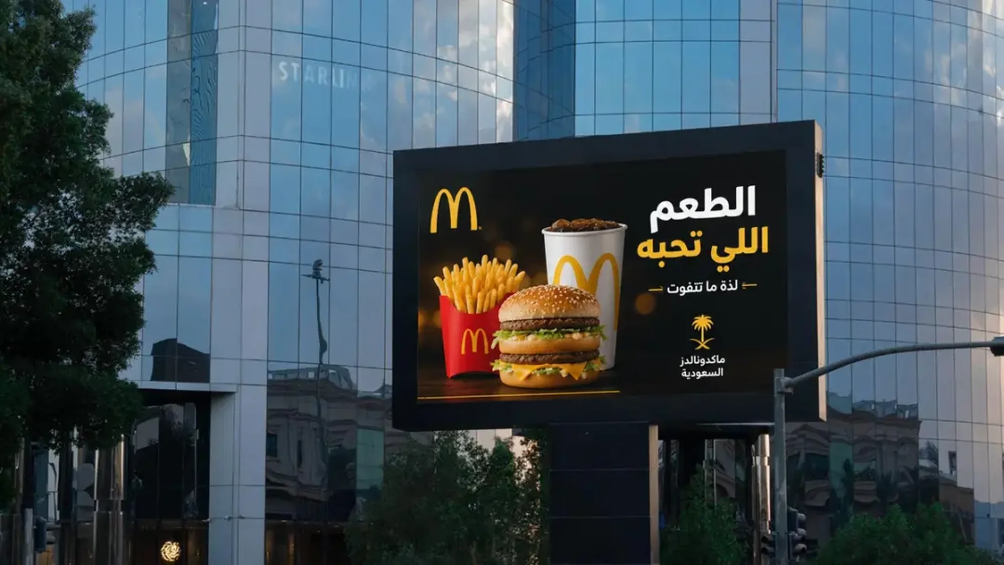 Digital out-of-home advertising in Saudi Arabia: a billboard shows a McDonald's Big Mac, fries and a drink, with Arabic text beside them.