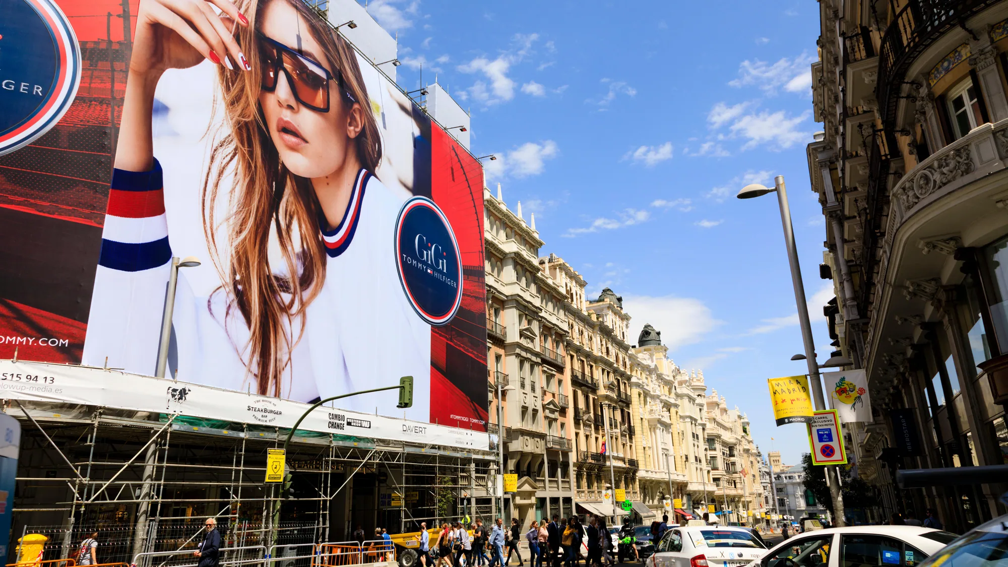 Billboard advertising on Gran Vía in Madrid, Spain: a Tommy Hilfiger Gigi board shows a woman in sunglasses.