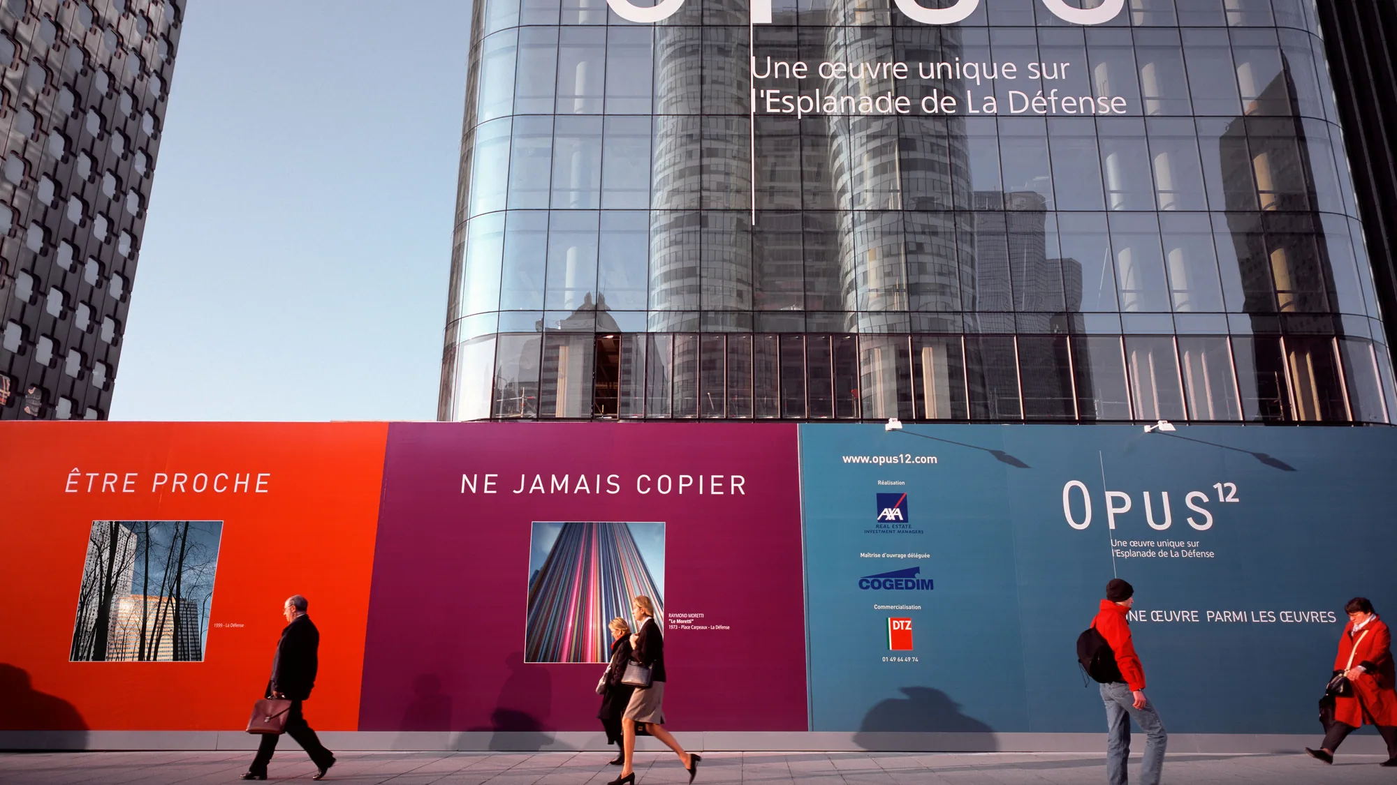 Building banner advertising at La Défense in Paris, France: a board of a leaping dancer covers Les Quatre Temps, above the steps of the plaza.