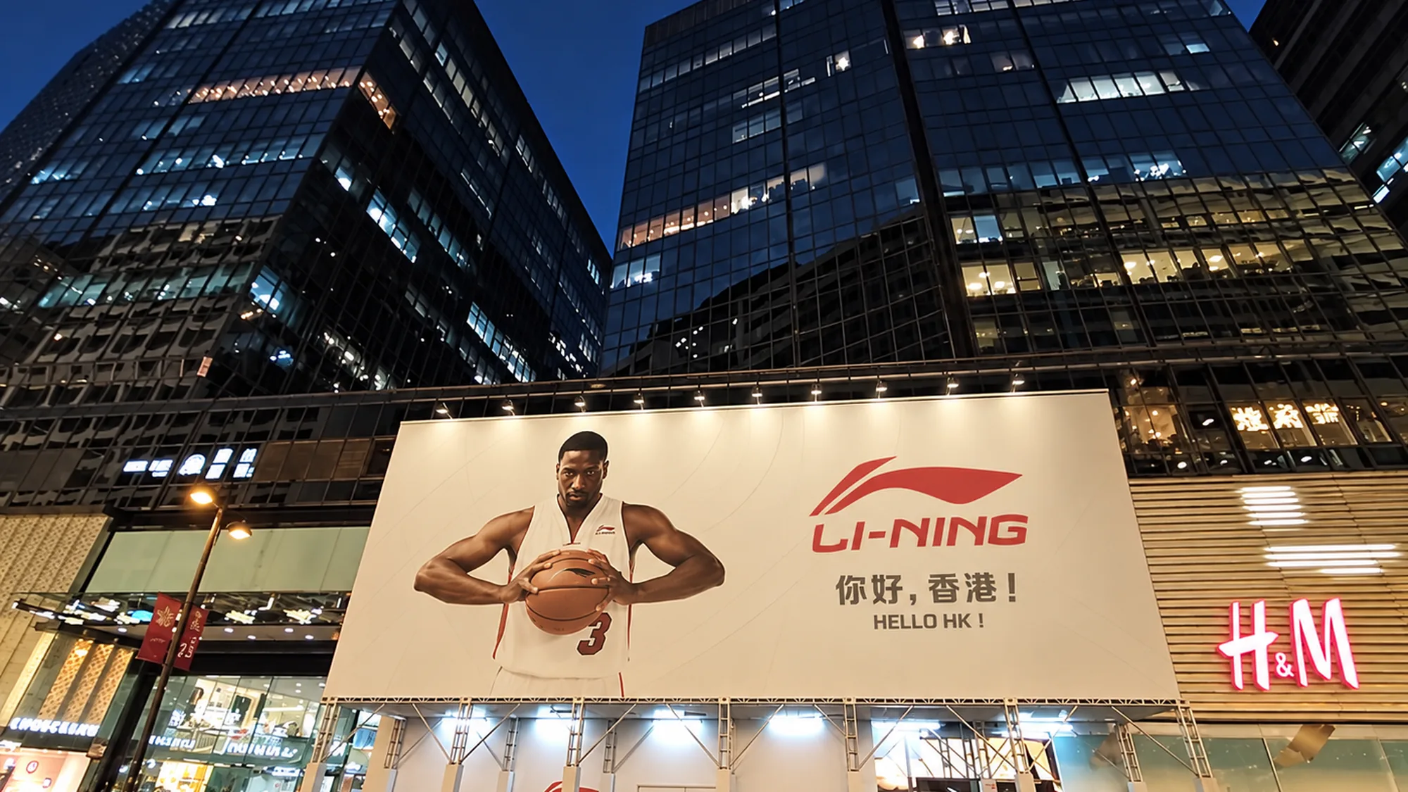 Billboard advertising in Hong Kong: a Li-Ning board reading hello HK shows a basketball player above an H&M.