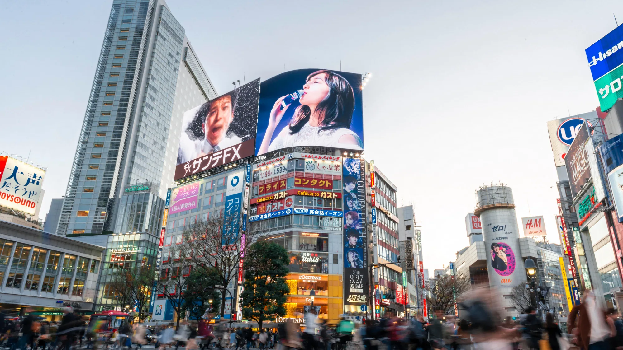 Digital billboard advertising at Shibuya Crossing in Tokyo: Yakult, Rakuten and other giant screens rise over the scramble as crowds gather.