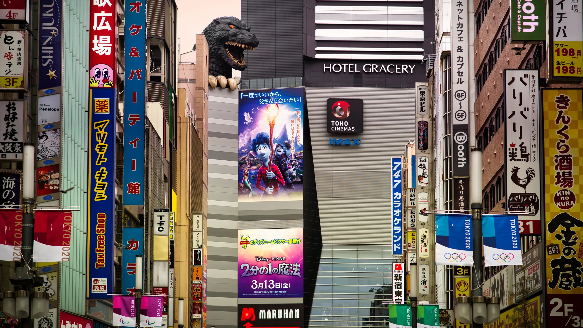 Outdoor advertising in Shinjuku, Tokyo: the Hotel Gracery Godzilla looms over Toho Cinemas, above a Disney Pixar film poster.