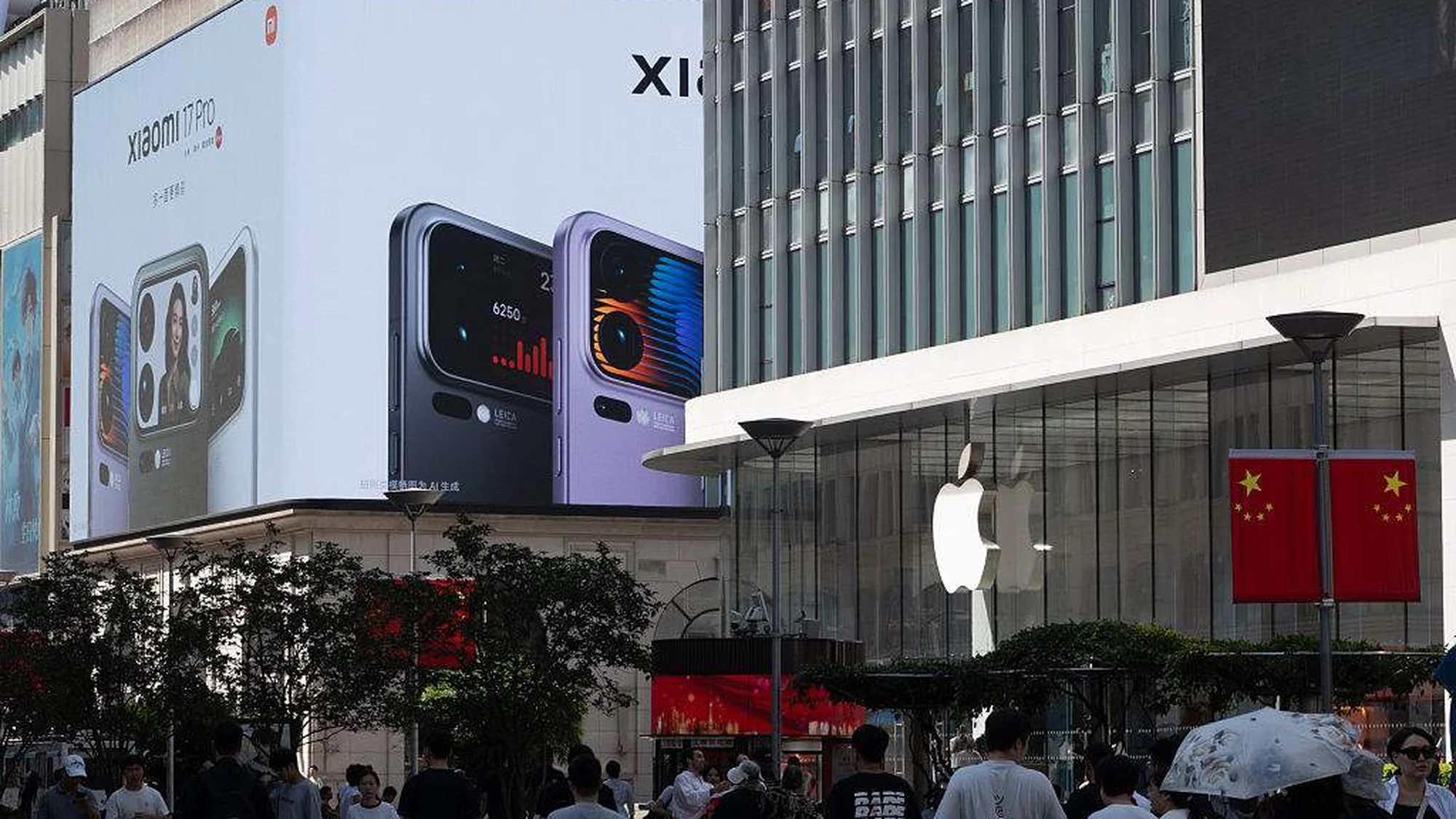 Digital out-of-home advertising in China: a corner screen at night shows a cartoon dog and a chocolate roll above a crowded shopping street.