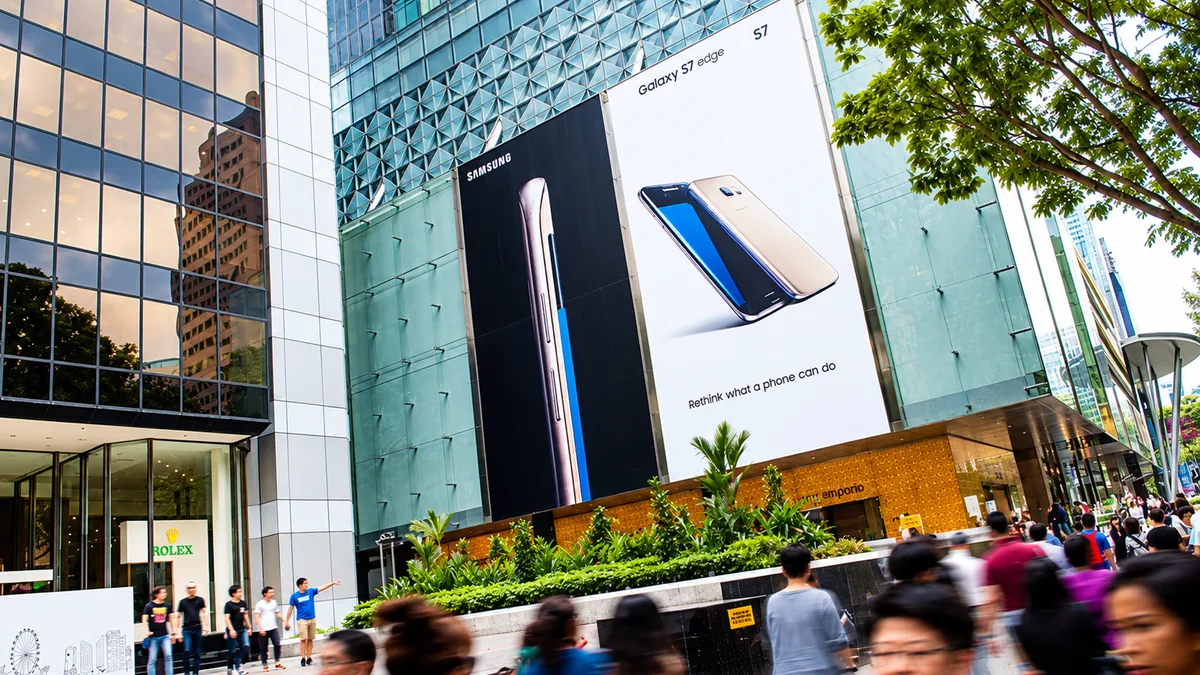 Building banner advertising: Samsung Galaxy S7 edge banners cover the glass facade of a tower above a busy pavement.