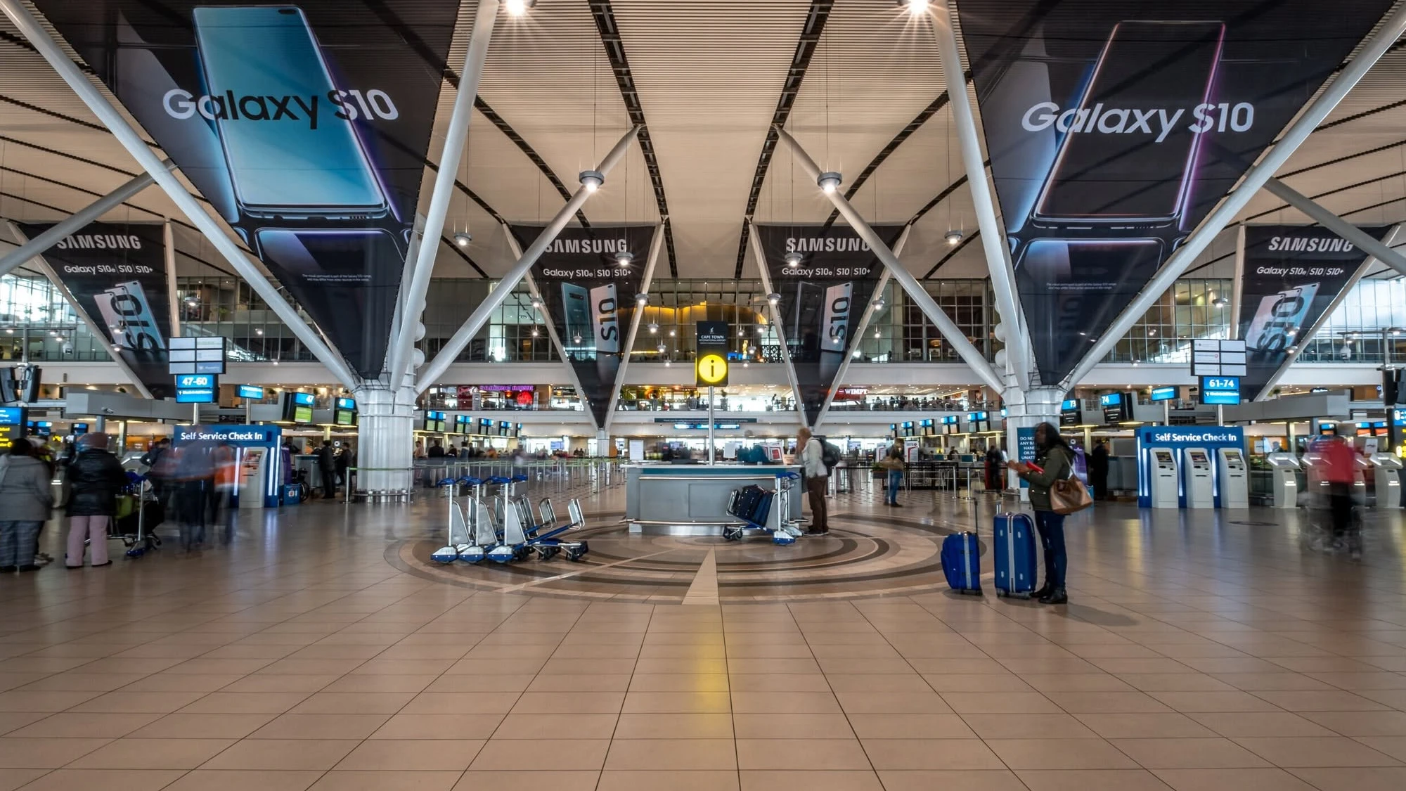 Airport advertising at Cape Town Airport in South Africa: Samsung Galaxy S10 banners hang from the roof trusses over the check-in hall.