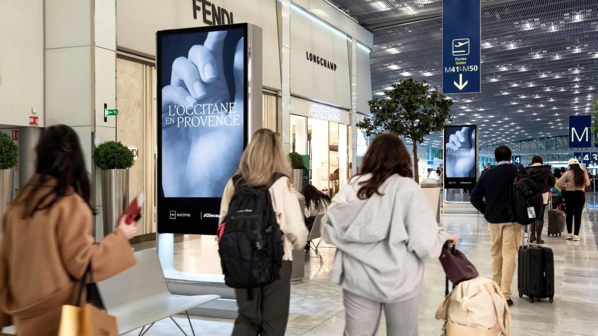 Programmatic airport advertising in Paris, in France: an airport screen shows L'Occitane en Provence beside Fendi and Longchamp.