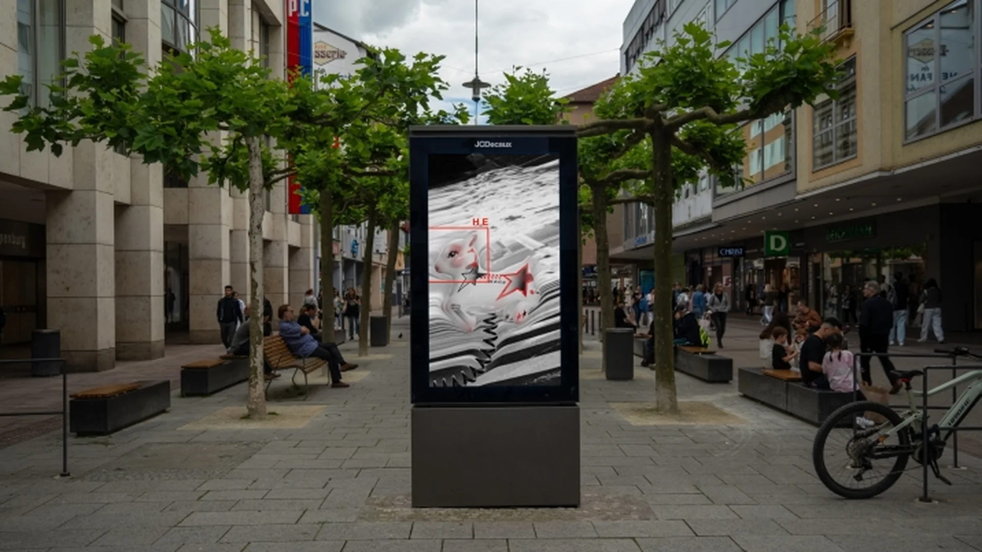 Programmatic digital advertising on a pedestrian street in Germany: a freestanding digital screen shows a white rabbit with red stars.