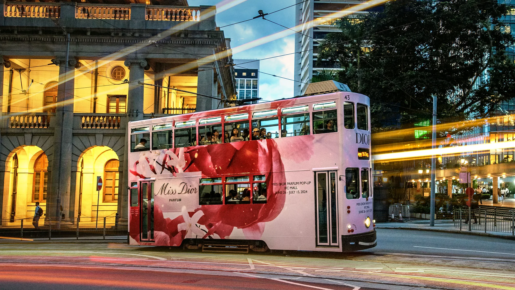 Tram advertising in Hong Kong: a double-decker tram is wrapped in Miss Dior Parfum artwork and advertises a pop-up at IFC Mall.