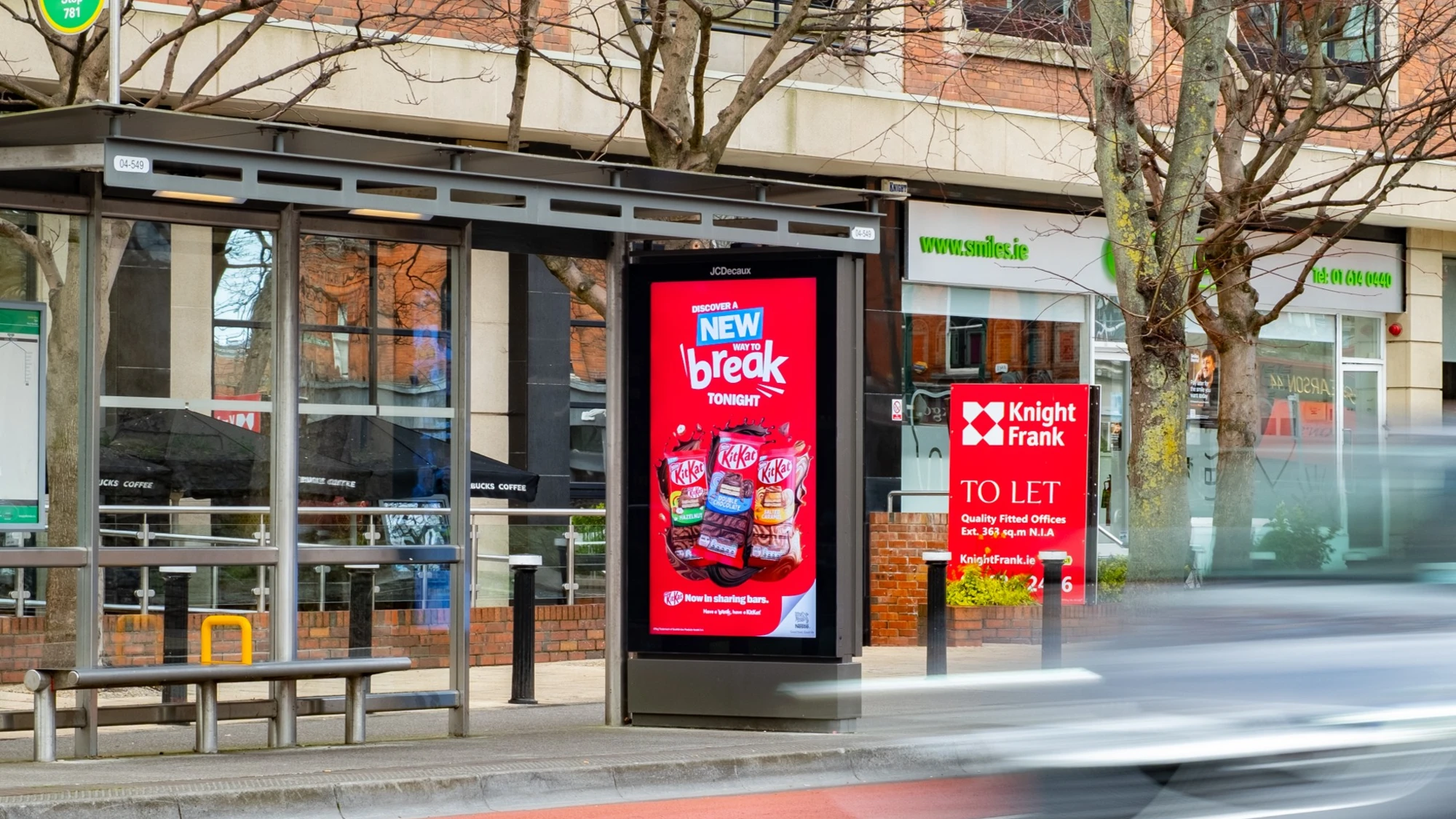 Programmatic digital advertising in Ireland: a bus shelter screen shows a KitKat advert reading Discover a new way to break tonight.