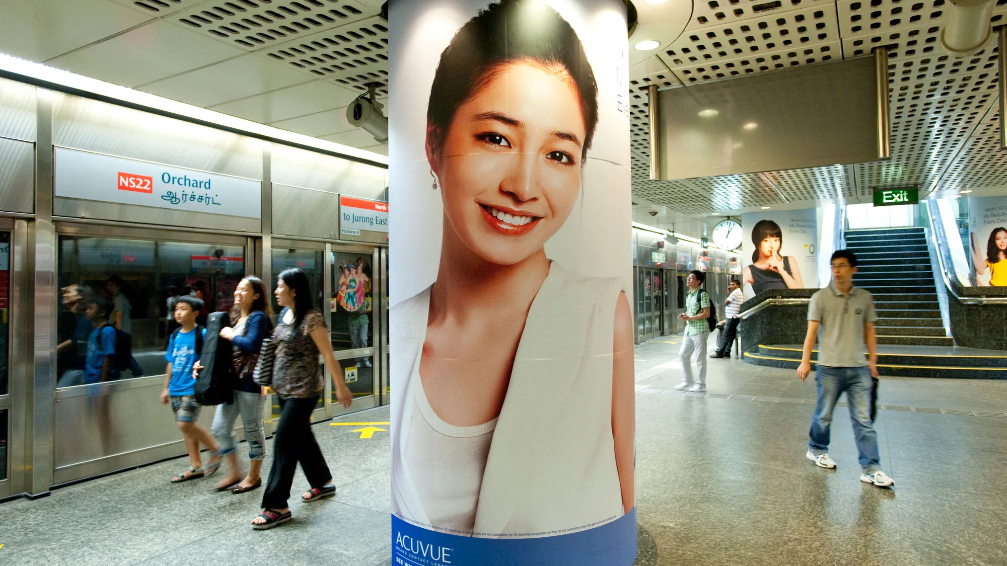 Underground advertising at Orchard station in Singapore: an Acuvue pillar poster carries the line See what could be, beside a waiting train.