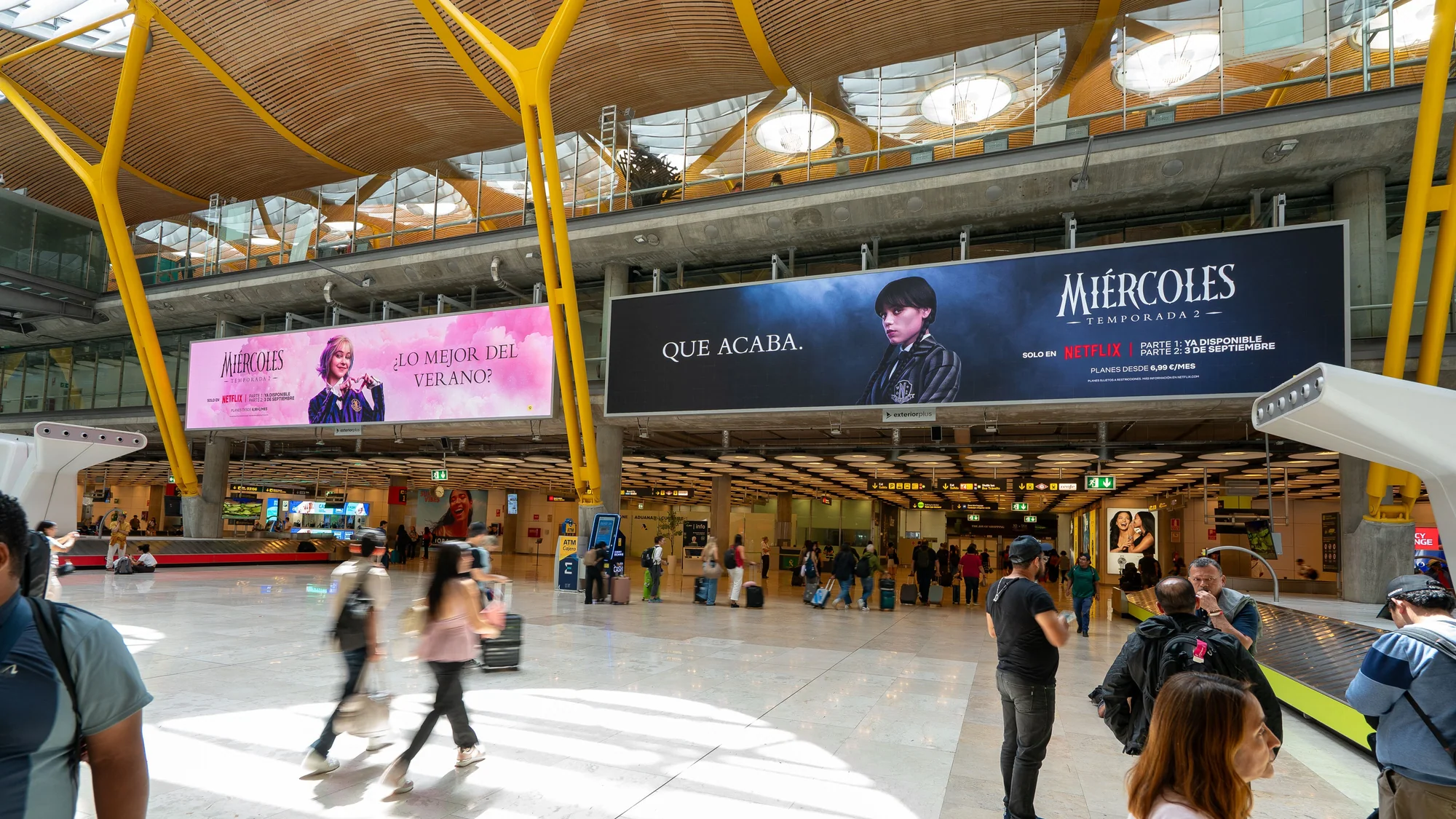 Airport advertising at Madrid airport in Spain: Netflix banners for Miércoles temporada 2 hang in the arrivals hall.