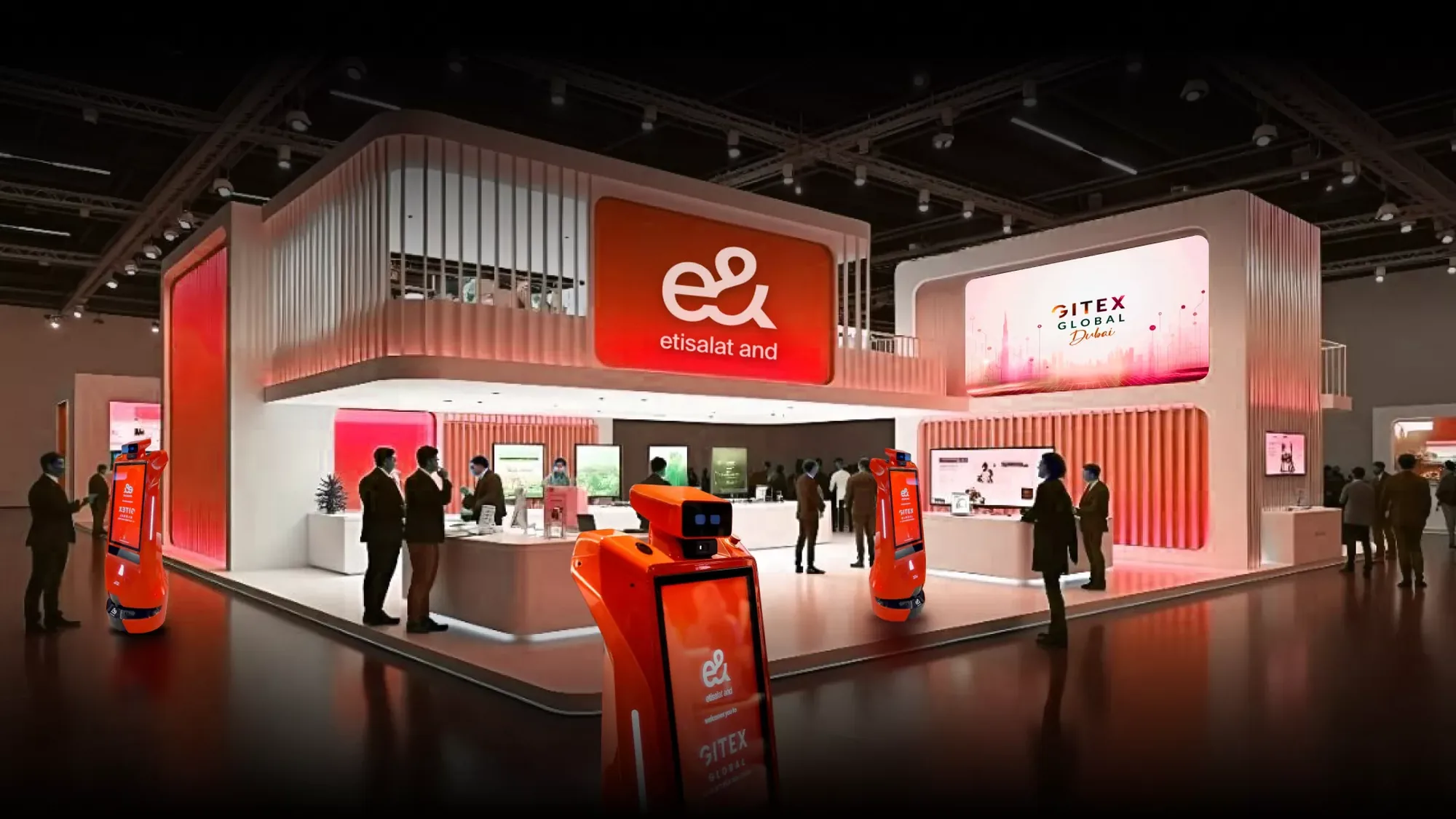 A brand activation in Dubai, in the UAE: an e& and etisalat stand at GITEX Global, with orange service robots in front of the booth.