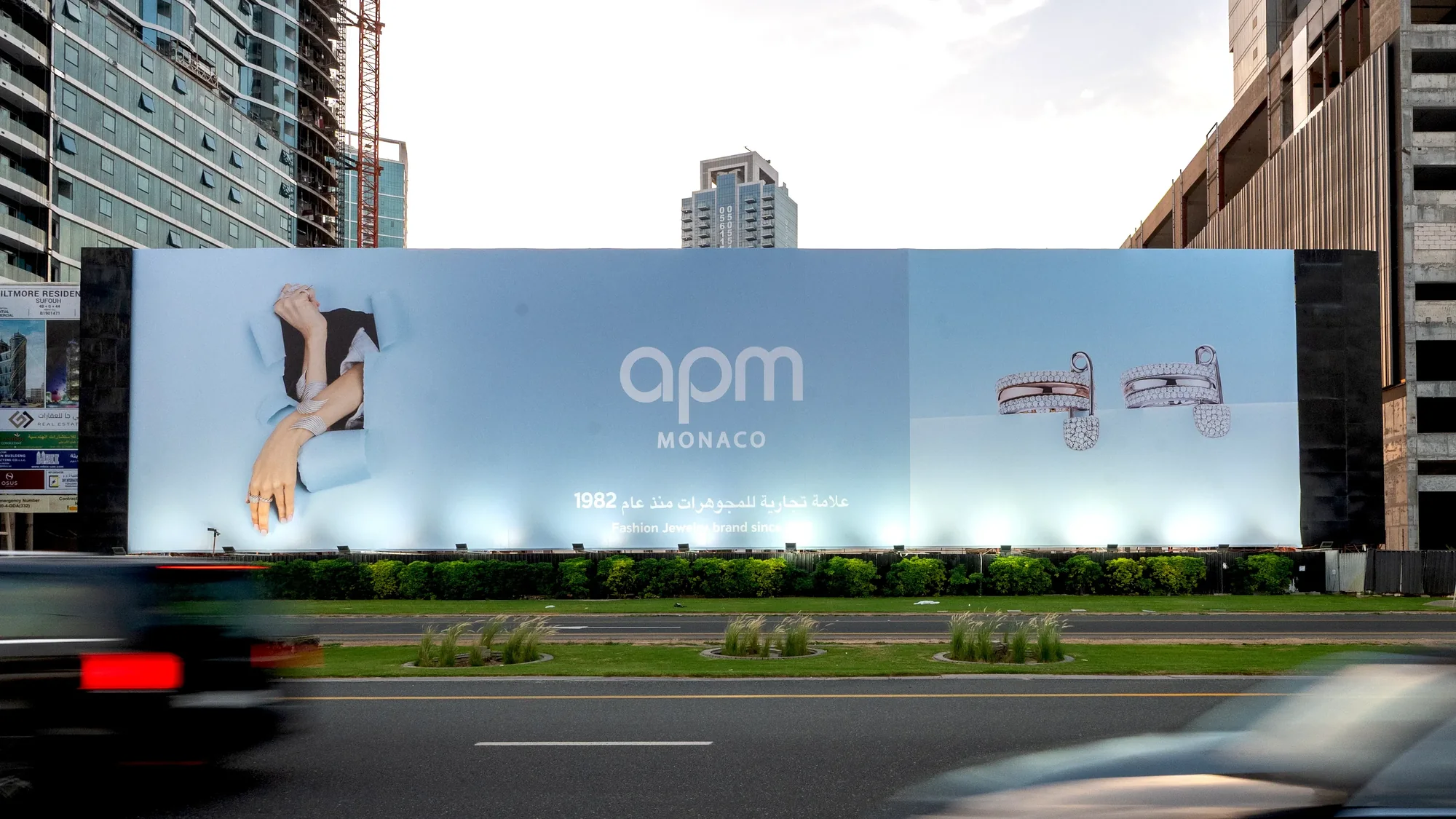 Billboard advertising in the UAE: a wide roadside board advertises APM Monaco jewellery, with a hand wearing rings and a pair of bracelets.