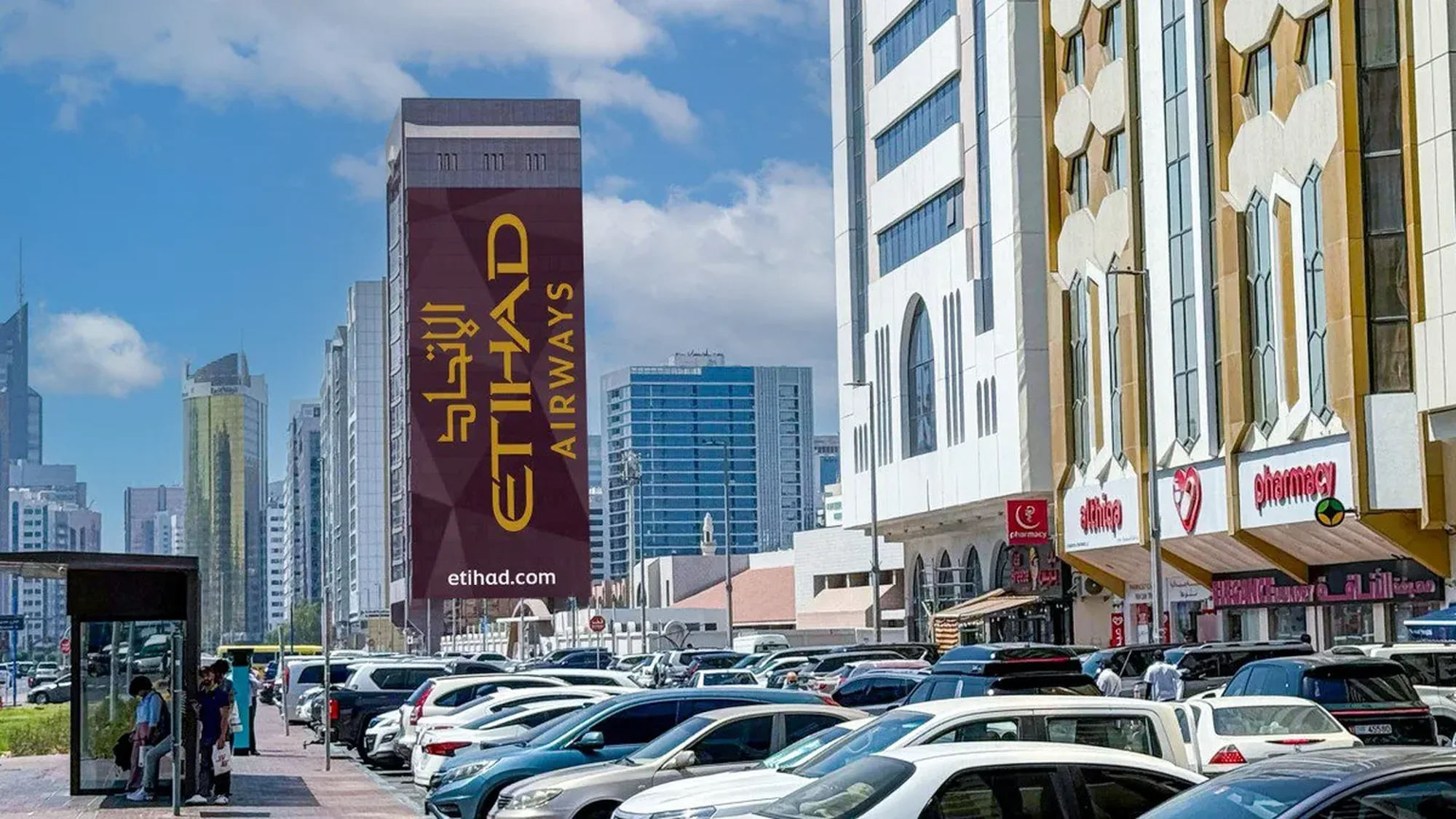 Building banner advertising in the UAE: a tall banner carries the Etihad Airways name above a street of parked cars.
