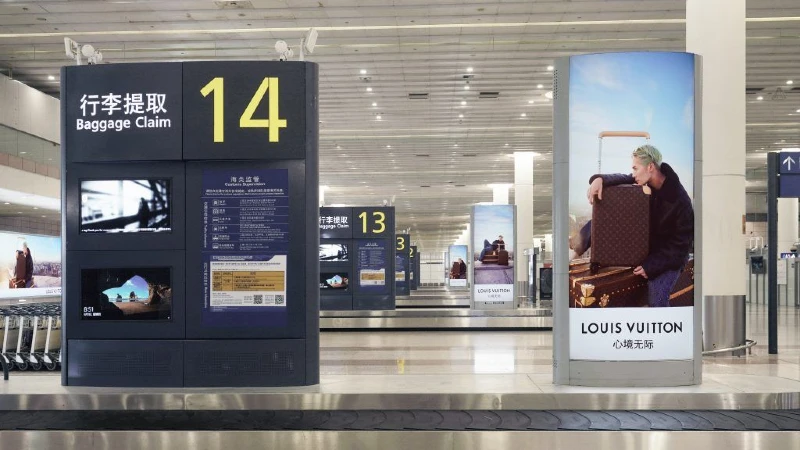 Airport advertising at baggage reclaim: a Louis Vuitton column advert stands beside carousel 14.