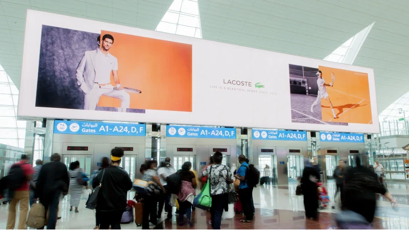 Airport advertising: a Lacoste tennis banner hangs above departure gates in a terminal.