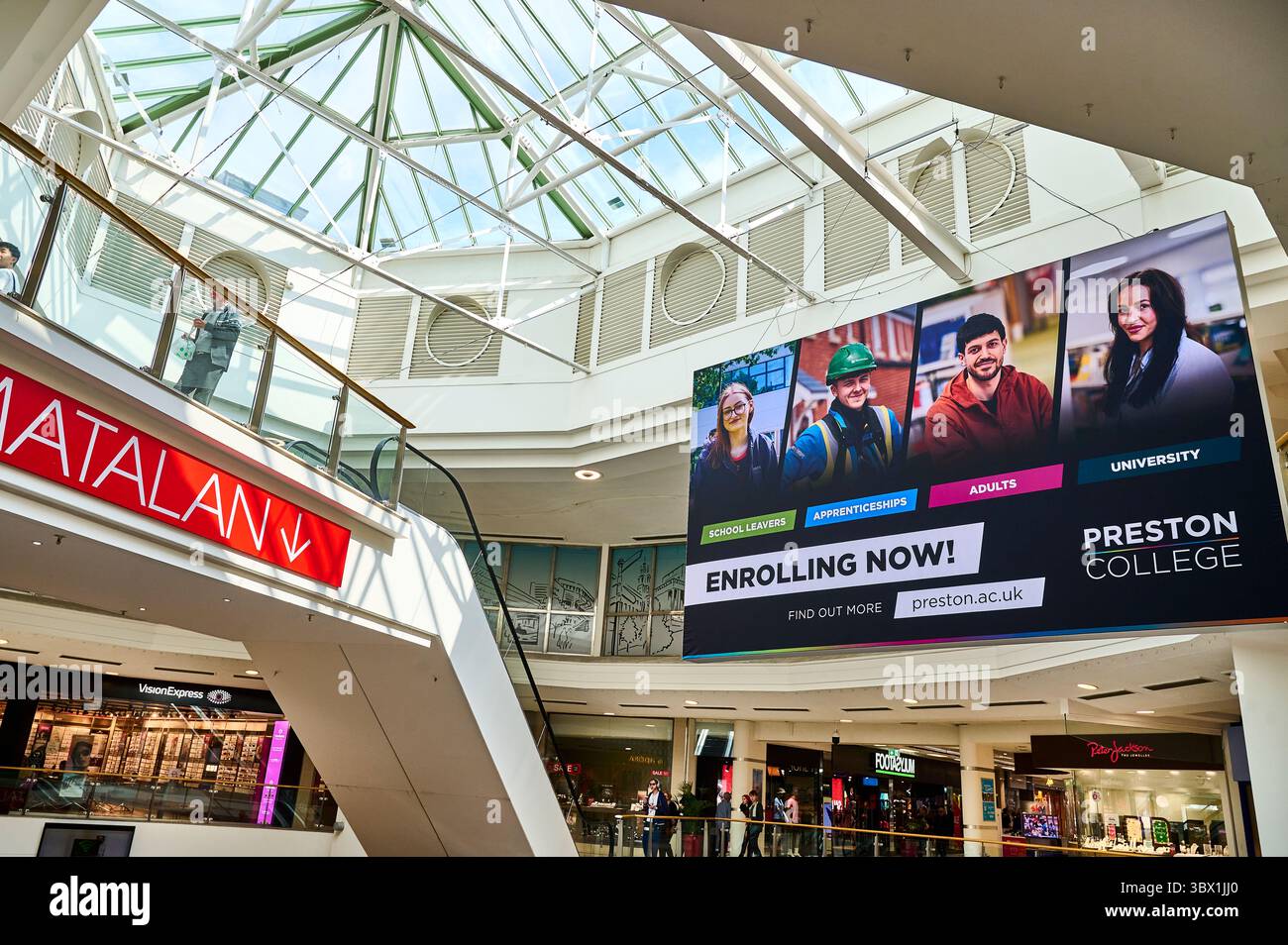 Mall advertising in the United Kingdom: a Preston College screen reading Enrolling now hangs beside a Matalan sign.