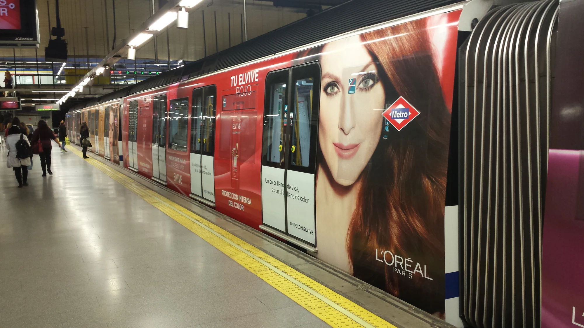 Metro advertising in Madrid, Spain: a train carries a red L'Oréal Elvive wrap along the platform.