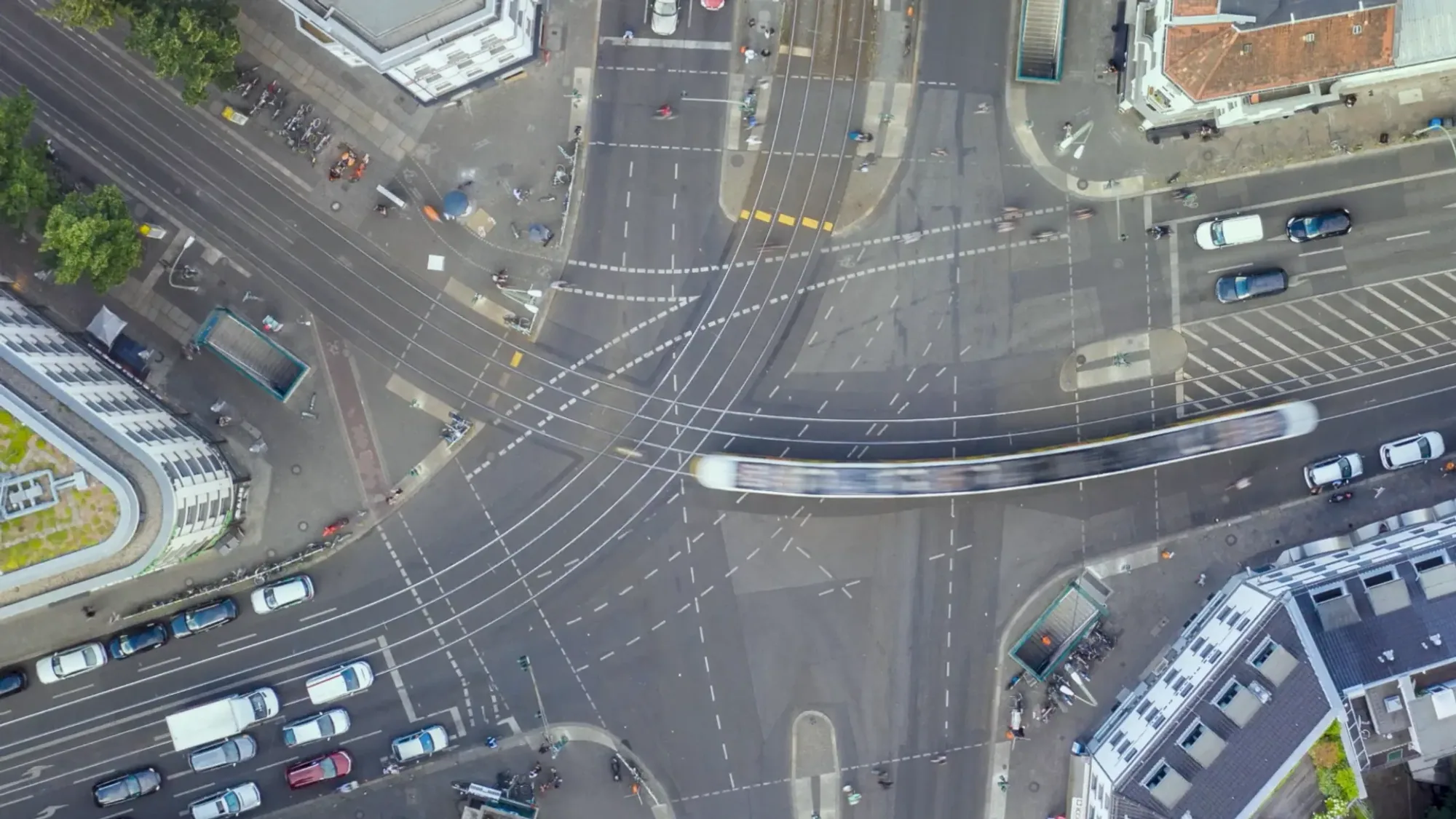 An overhead view shows a tram crossing a busy multi-lane junction in Germany.