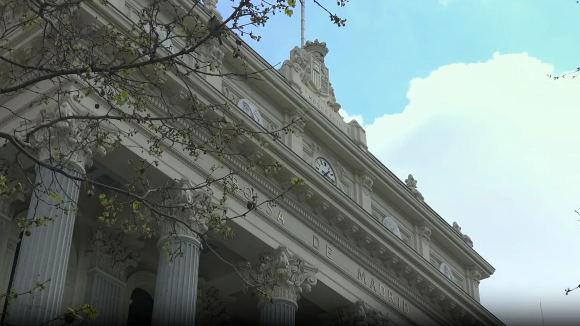 A white columned building in Madrid carries a clock and the carved words de Madrid.