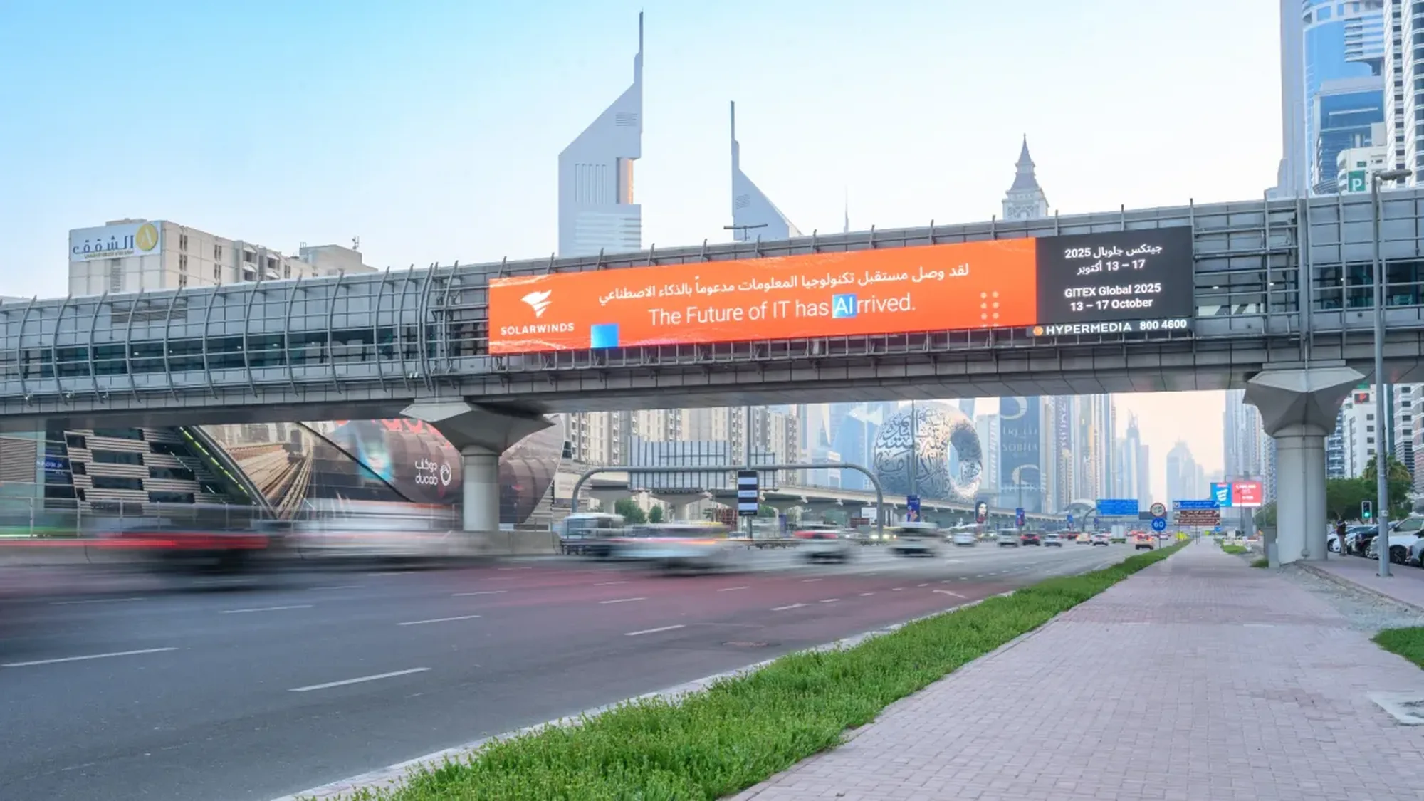 Digital bridge banner advertising: a SolarWinds screen on a pedestrian bridge reads The Future of IT has Arrived above highway traffic.