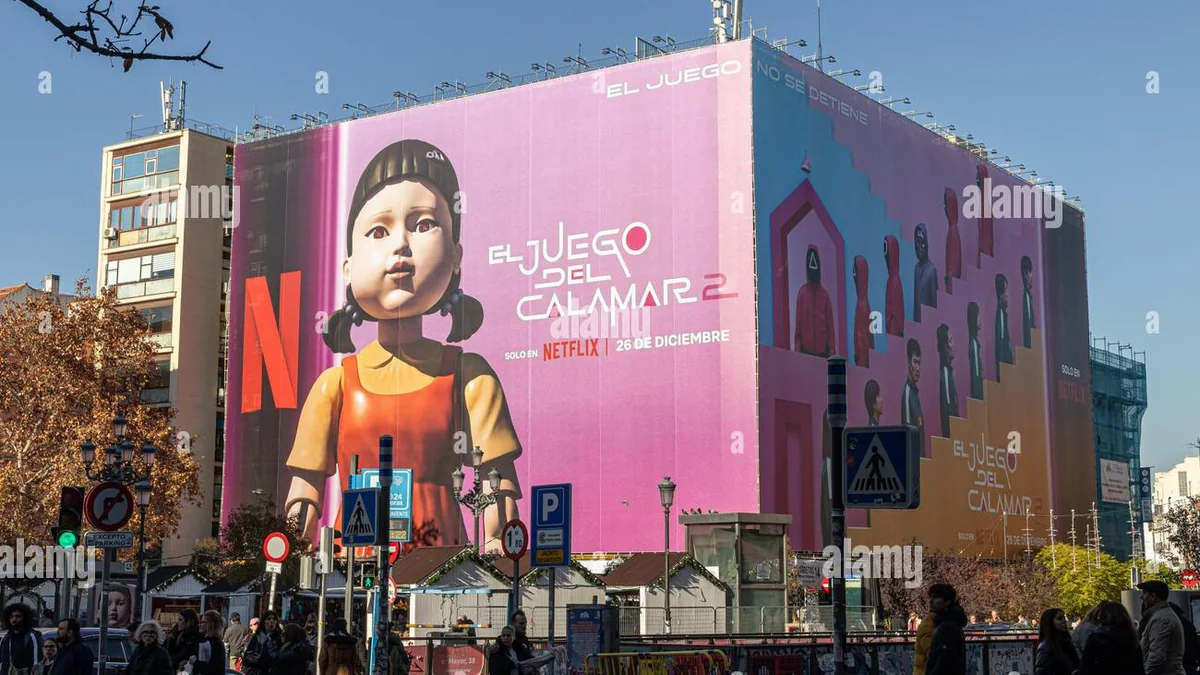 Building wrap advertising: a Netflix wrap for El Juego del Calamar 2 shows the doll above a city junction.