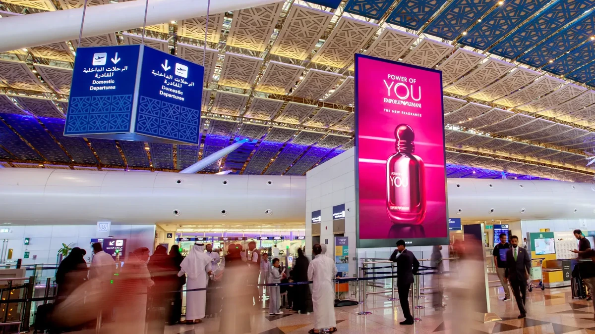 Atrium screen advertising: a tall pink screen in a departures hall shows Emporio Armani Power of You, the new fragrance, beside a hanging Domestic Departures sign.
