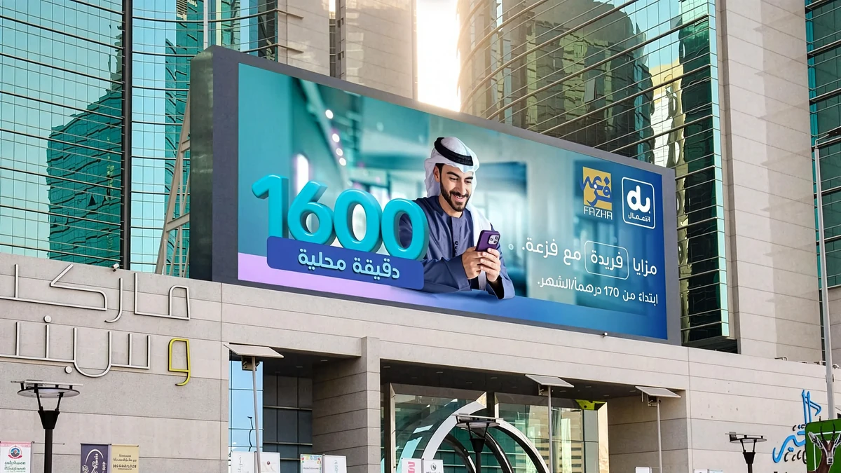 Dynamic creative advertising: a wide du and Fazha screen on a glass building shows a man in a ghutra looking at a phone, with the number 1600 for local minutes.