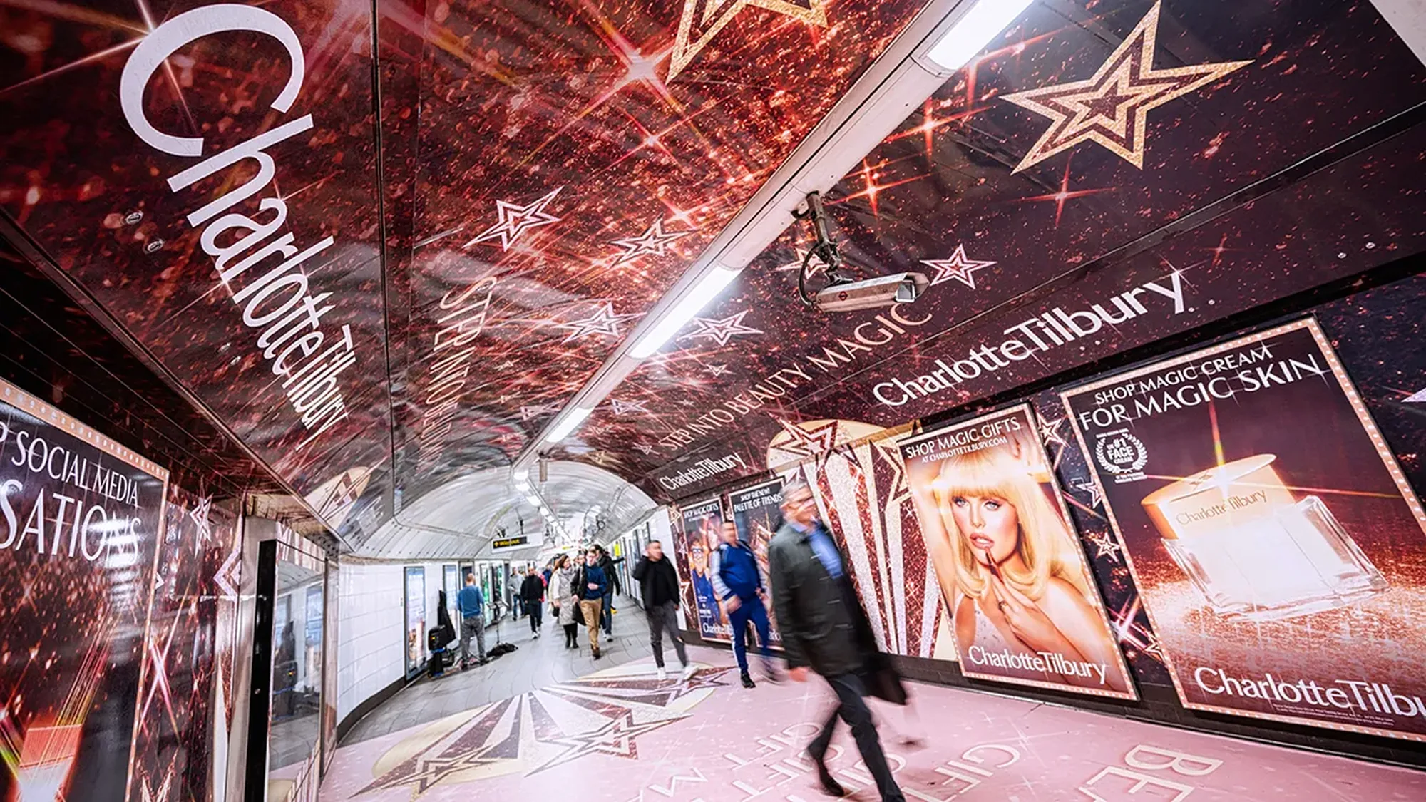London Underground station domination advertising in the United Kingdom: a Charlotte Tilbury takeover covers the walls, ceiling and floor of a tunnel.