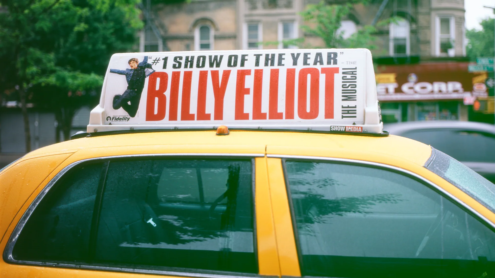 Taxi roof advertising in New York: a yellow taxi sign advertises Billy Elliot the Musical.